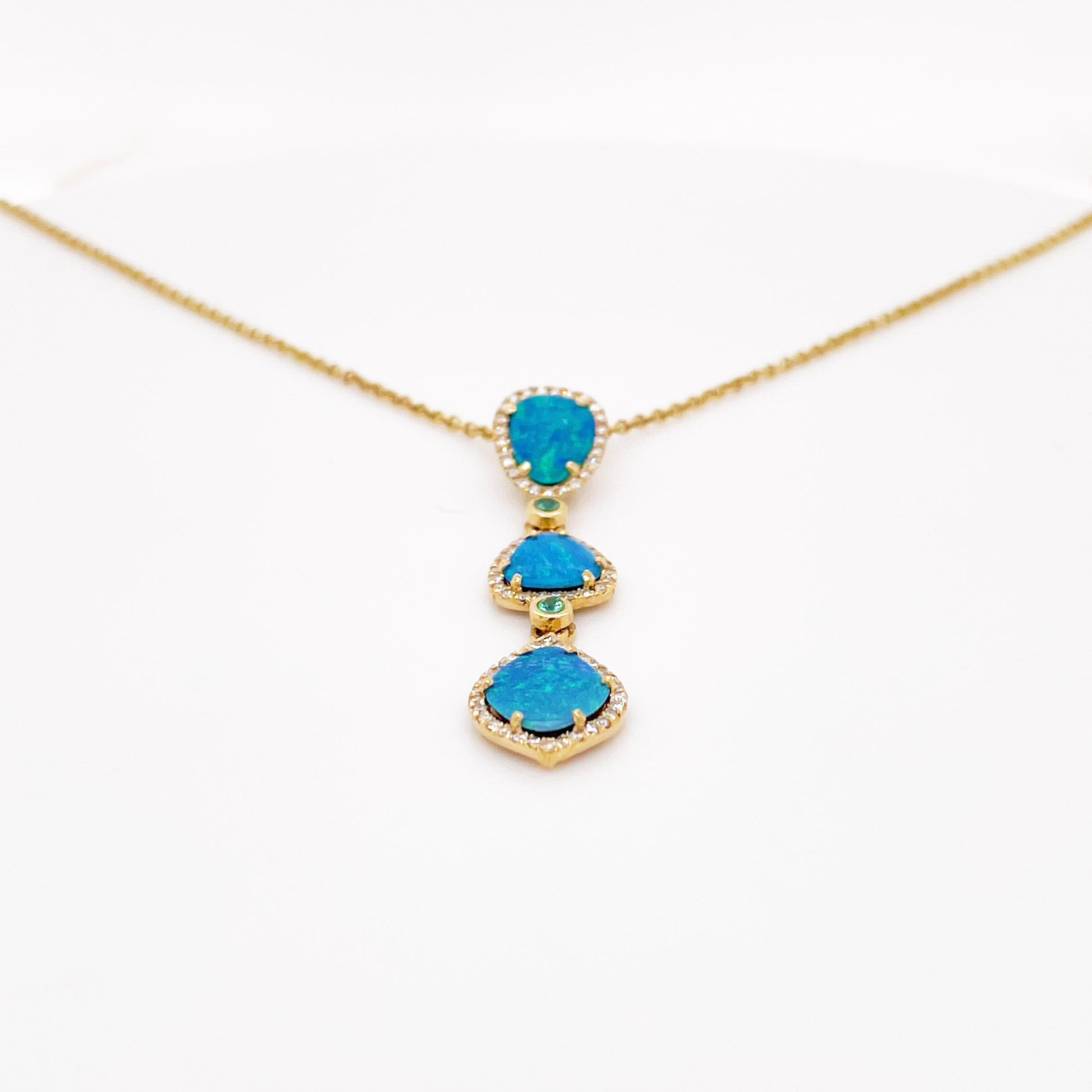 These stunningly beautiful black opal doublets are set in polished 14k yellow gold prongs that are dripping with diamonds. The piece has two beautiful emeralds that provide a look that is very modern yet classic! This necklace is very fashionable