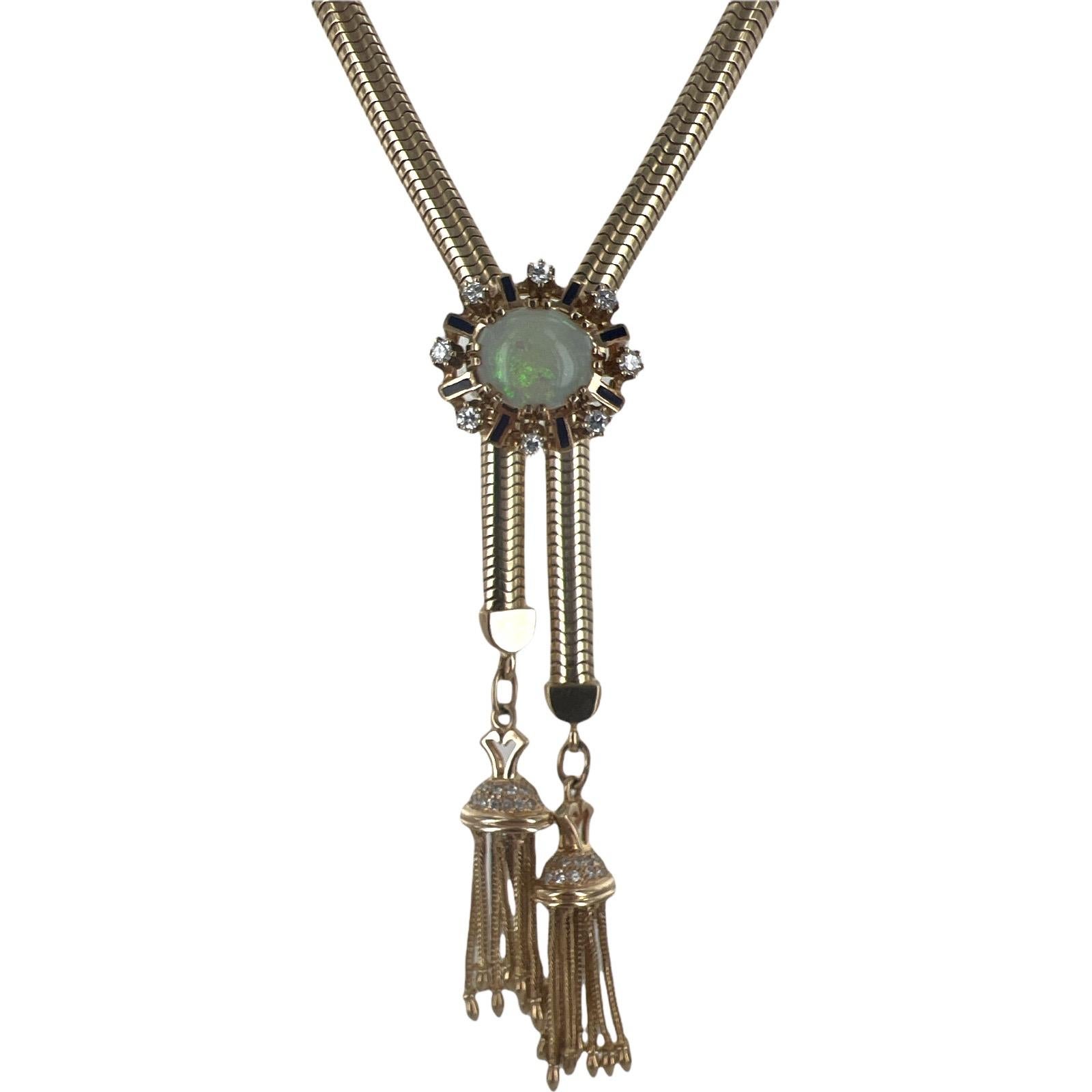 Fabulous vintage lariat tassel necklace fashioned in 14 karat yellow gold. The adjustable necklace features diamond endcaps with tassel drops. The center pendant features an oval opal, enamel, and 10 round brilliant cut diamonds. The diamonds all