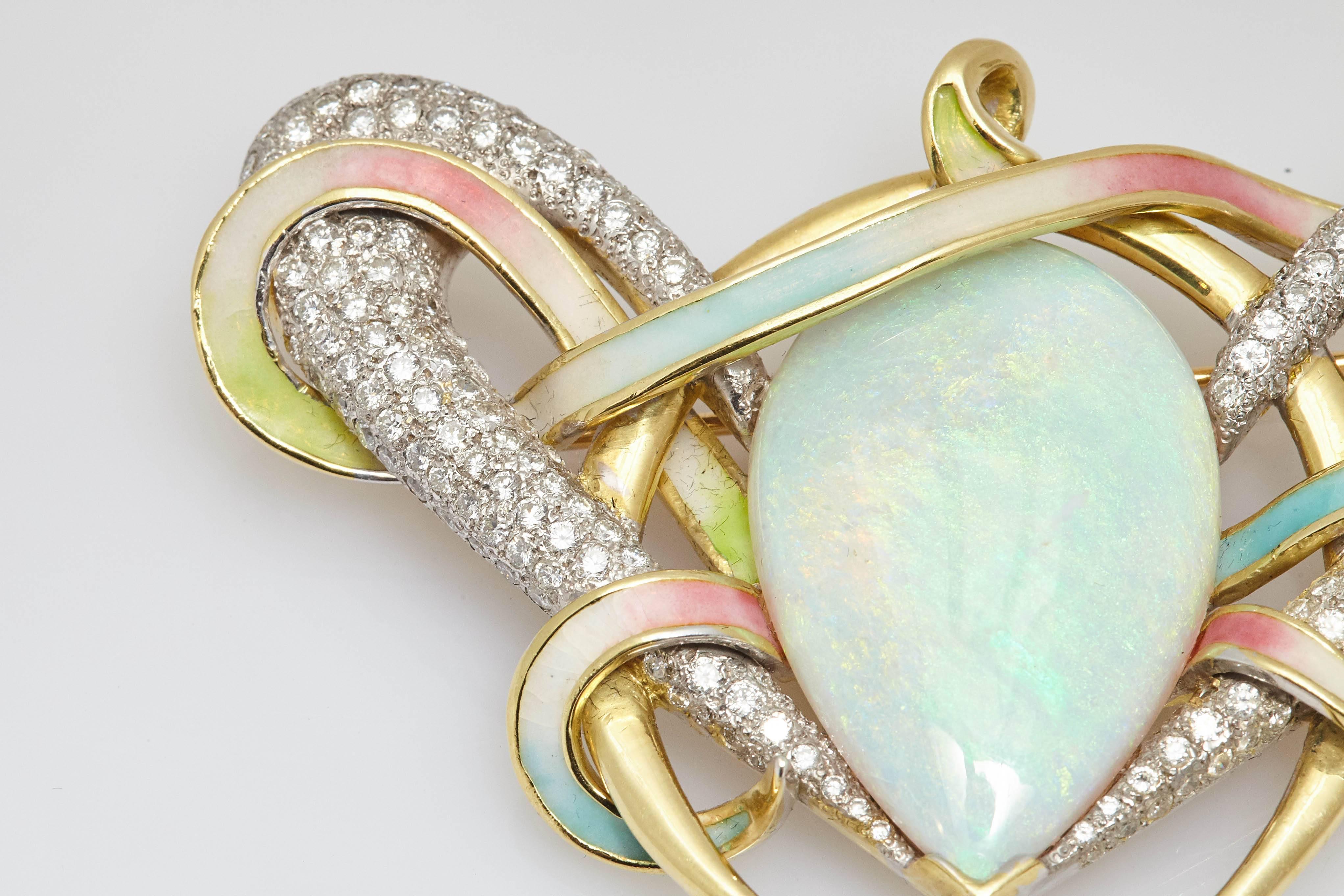 An unusual brooch centering a large pear shaped opal, in a mounting of planetary inspiration with round cut diamonds and multicolor enamel, set on 18kt yellow gold. Made in the United States, circa 1970s.