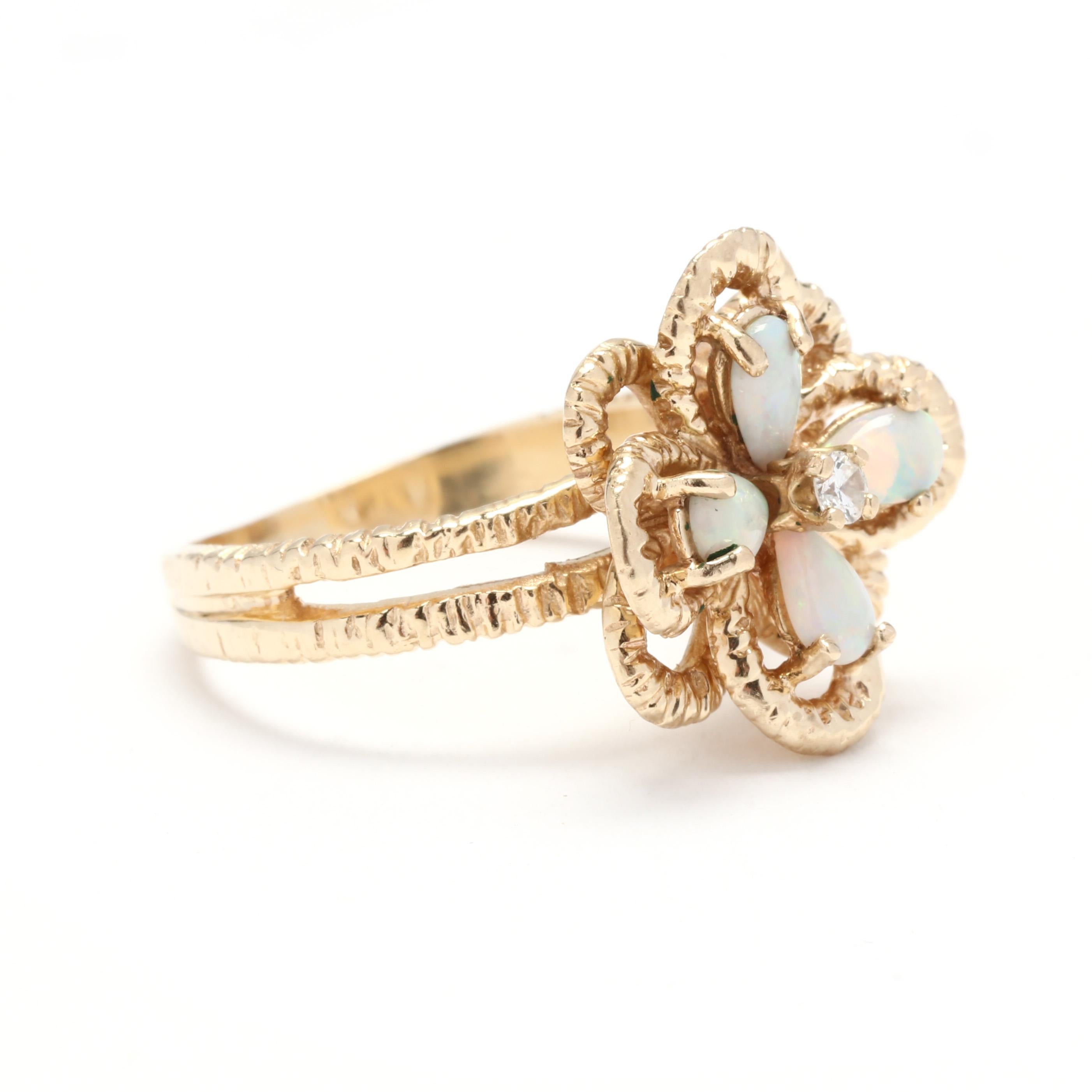 A 1970's 14 karat yellow gold opal and diamond flower cocktail ring. This ring features four prong set, pear cabochon cut opals weighing approximately .48 total carats centered around a round brilliant cut diamond weighing approximately .04 carat,