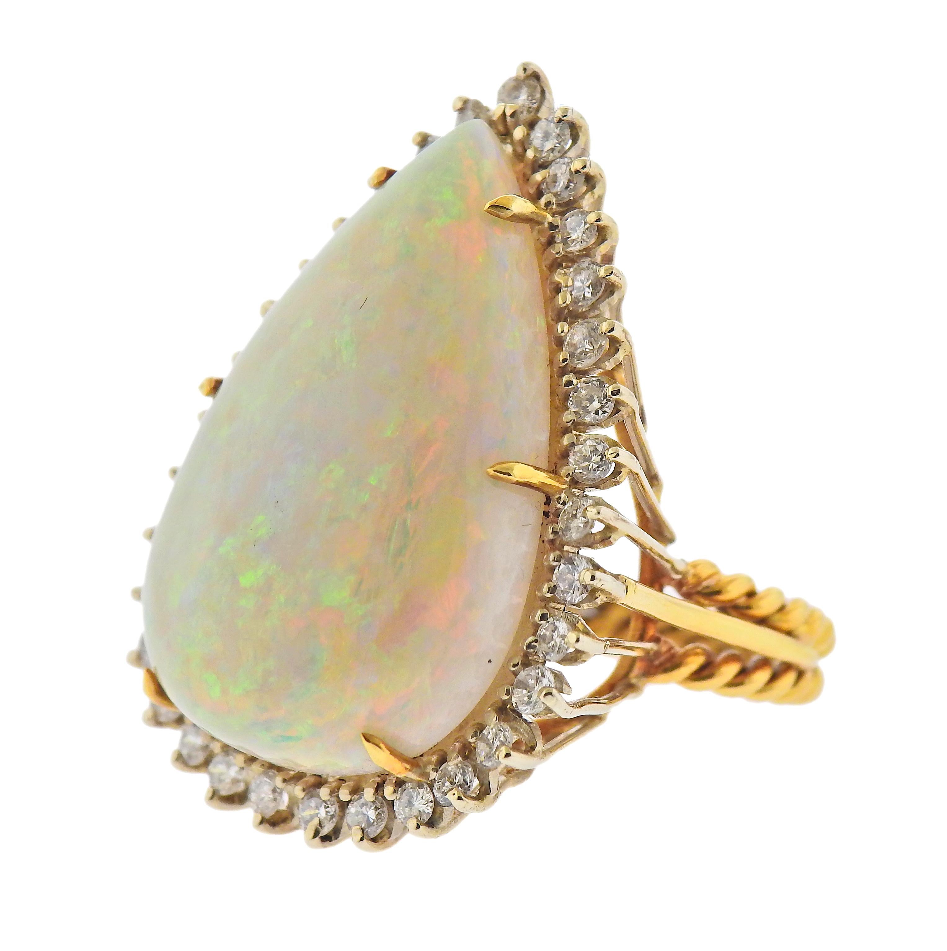 Large 18k gold cocktail ring, featuring pear shape 30mm x 20.6mm x 8.4mm opal gemstone. Surrounded with approx. 1.10ctw in diamonds. Ring size - 8.5, ring top - 36mm x 26mm. Weight - 16.4 grams. 