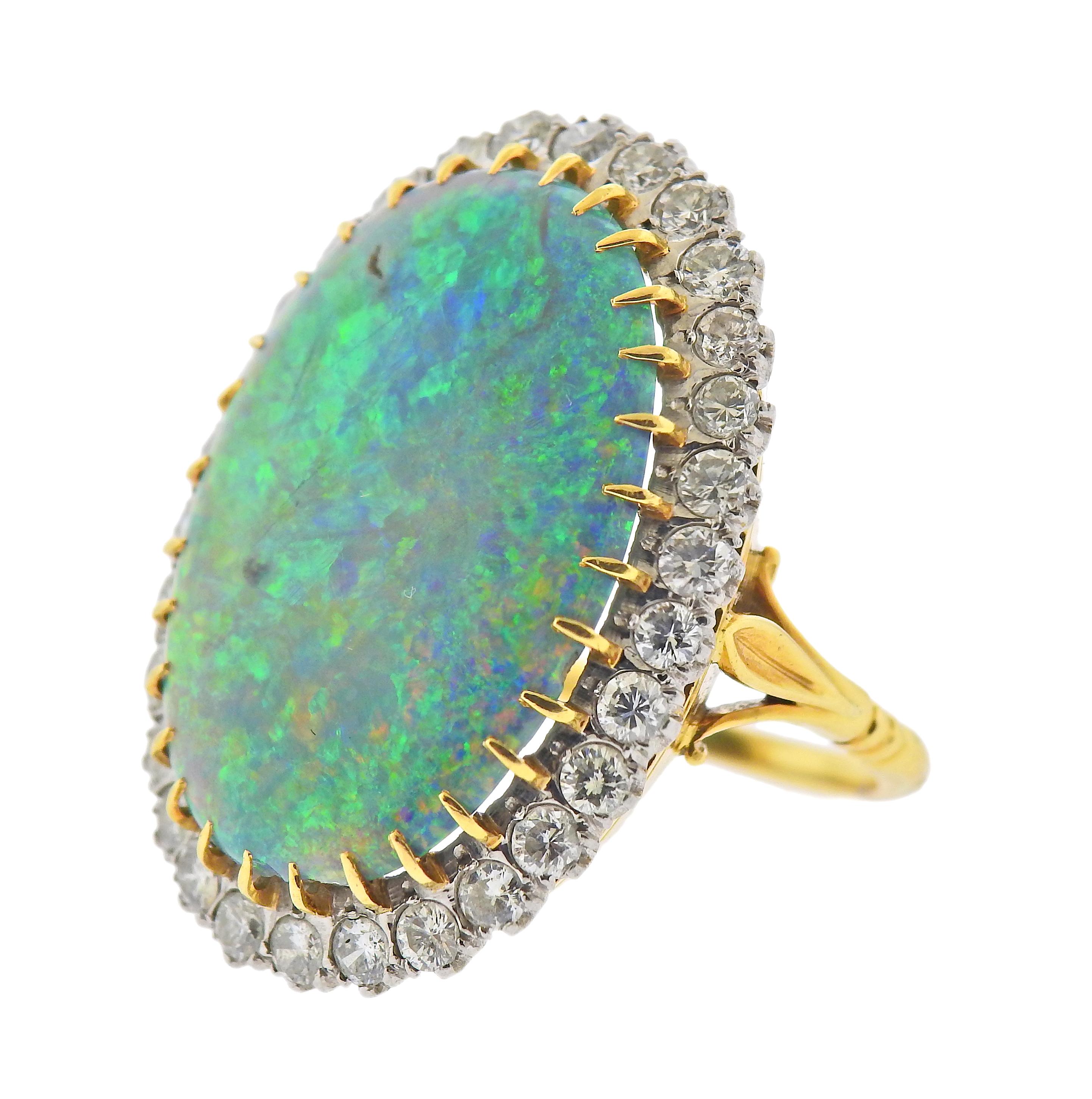 18k gold cocktail ring, with oval 25 x 18.3mm x 4.9mm opal, surrounded with approx. 1.60ctw in diamonds. Ring size - 7, ring top - 31mm x 25mm. Weight - 12.9 grams. 