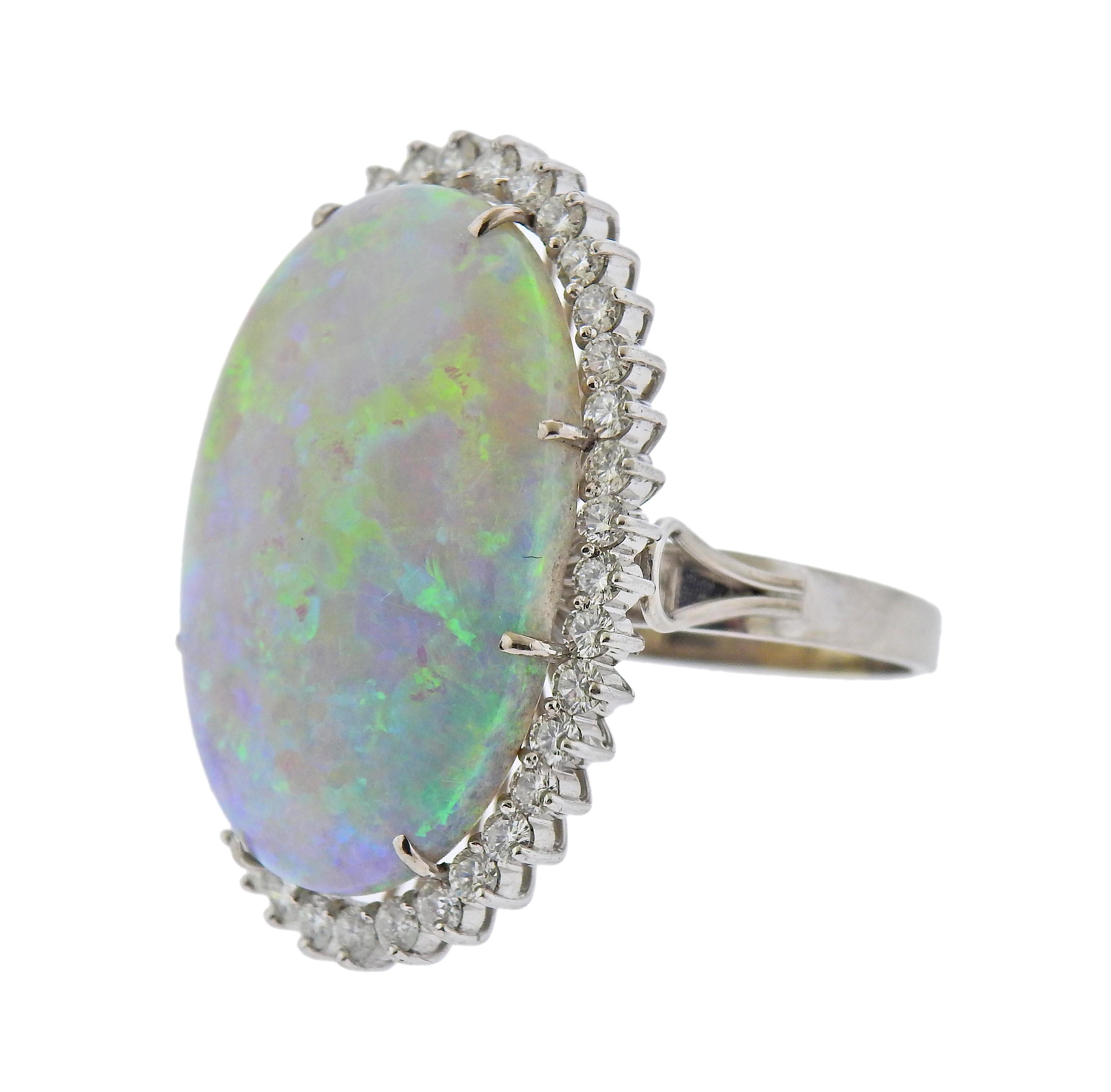 18k gold cocktail ring with oval opal, measuring 29.5 x 20.3mm, surrounded with approx. 1.20ctw in diamonds. Ring size - 9.5, ring top - 35mm x 25mm. Marked 18k. Weight - 14 grams. 