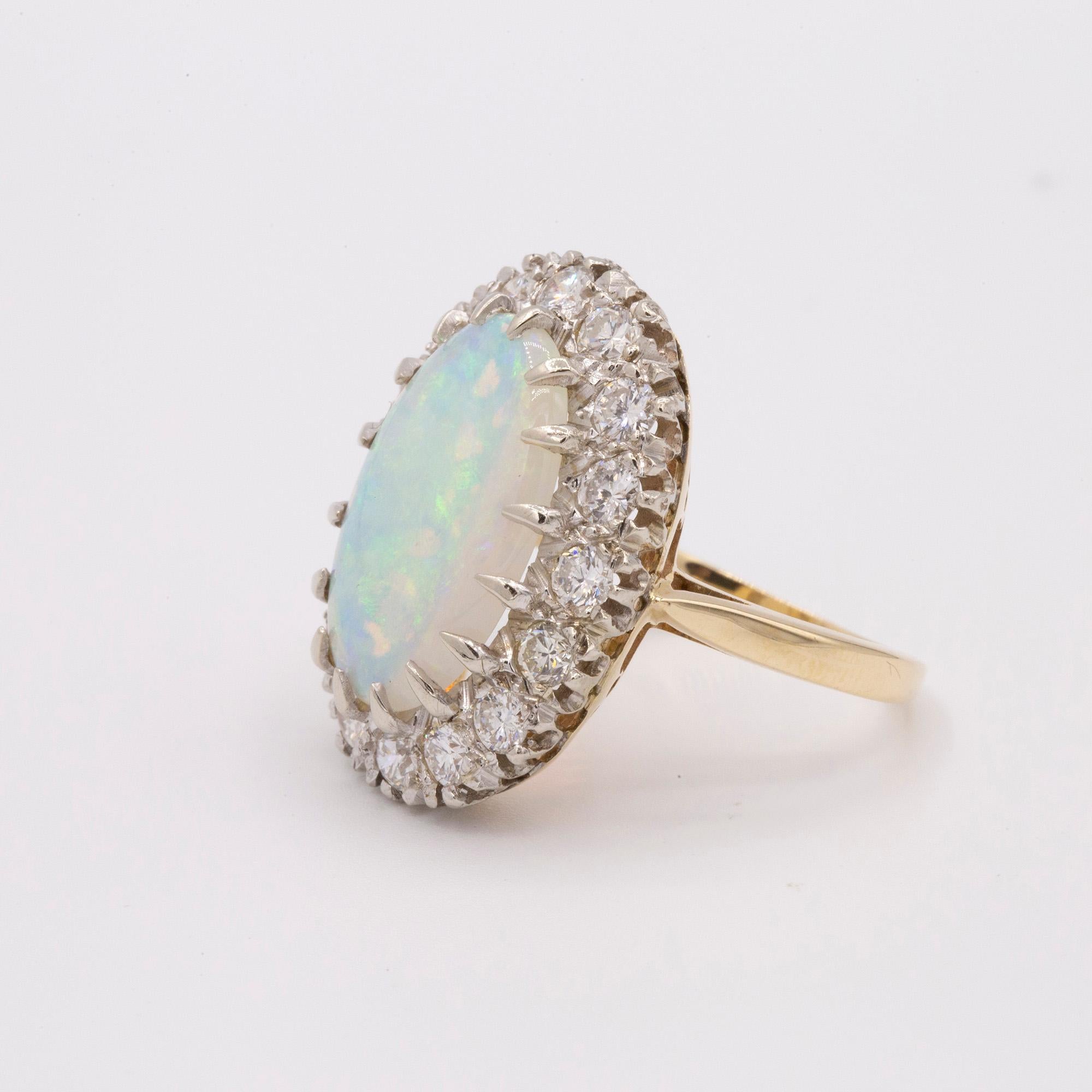 14kt Yellow Gold ring set with one Oval shaped Opal and prong set Diamonds in a halo style. 

The total Diamond weight is 1.10ctws.

The ring is a Size 6.5 & can be sized.