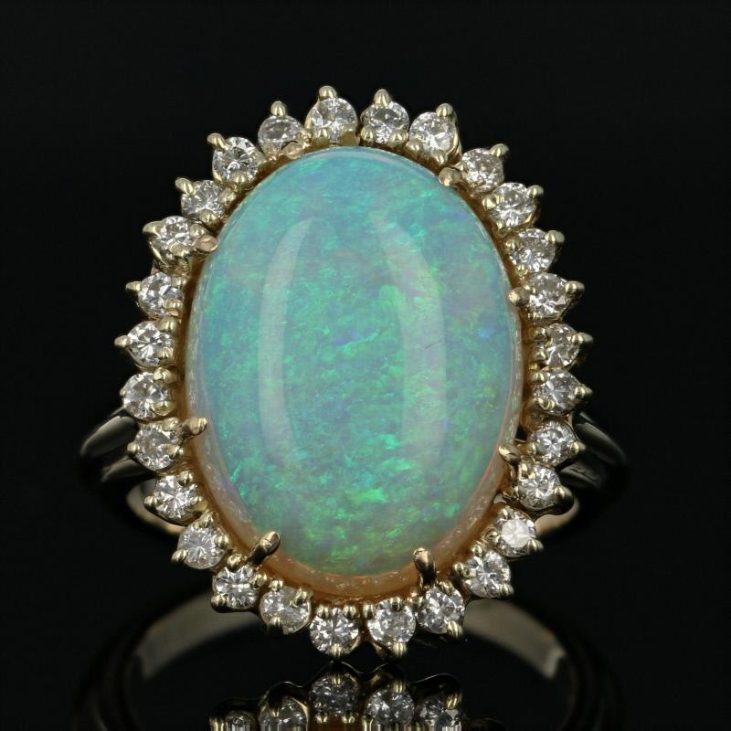 Red carpet glamour awaits you every time you slip on this exquisite cocktail ring! Displaying a great play of color, this fine quality opal solitaire showcases electric blue and green hues over glowing orange to give this gemstone the appearance of