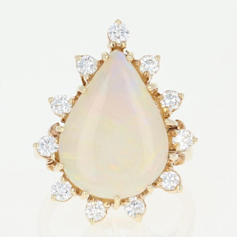 This spectacular cocktail ring is destined to become a treasured piece in your jewelry collection! Fashioned in a majestic halo design, this 14k yellow gold ring showcases a breathtaking opal solitaire that is elegantly framed by brilliantly