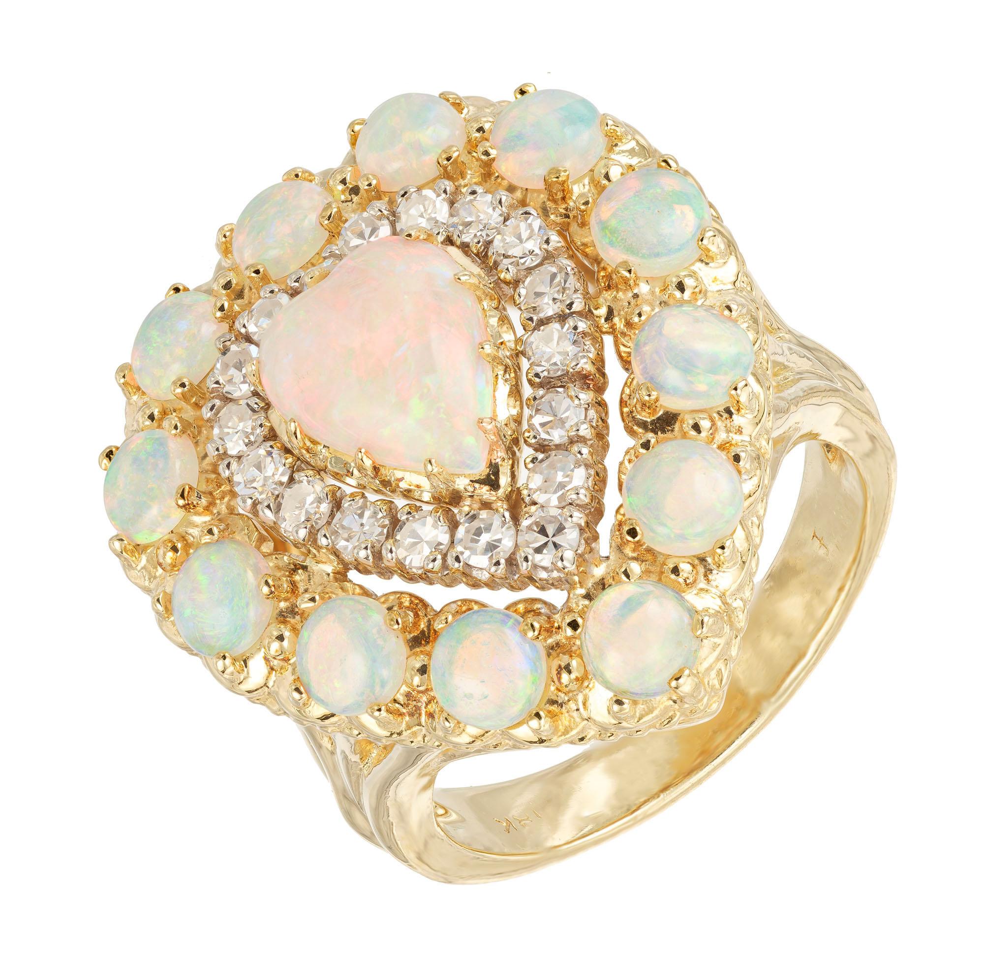 1950's Opal and diamond cluster cocktail ring. Heart shaped center opal with a halo of single cut round diamonds with a second halo of round cut opals, set in a 18k yellow gold setting. 

1 heart shaped opal .80cts
12 round opals 1.20cts
18 single