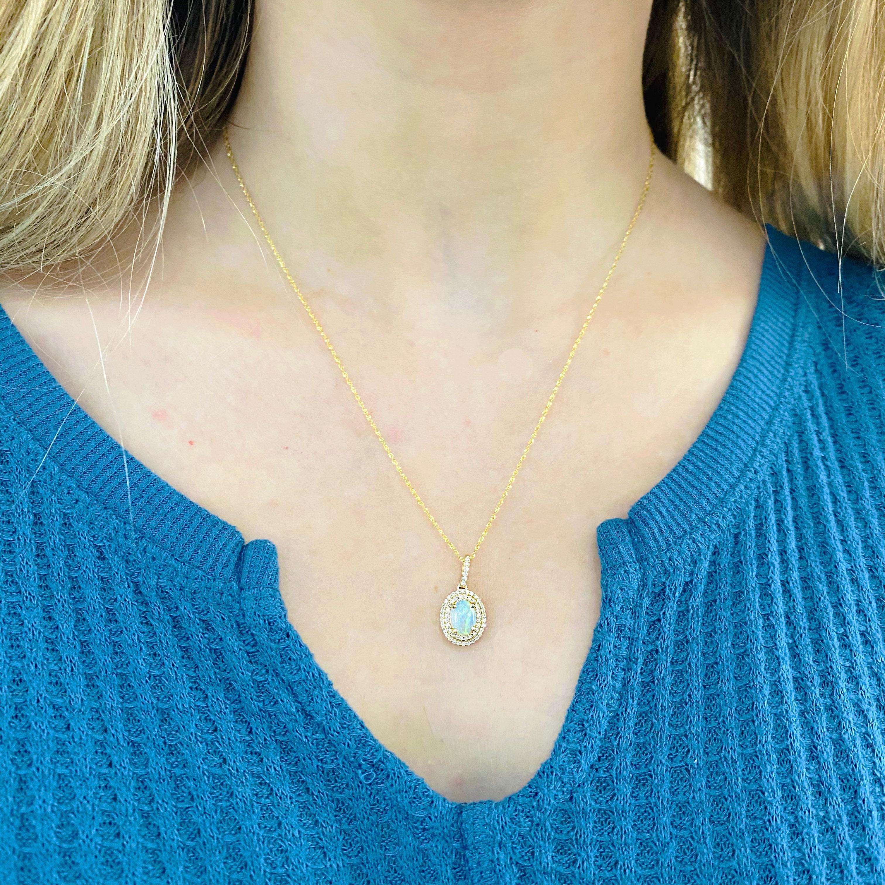 This stunningly beautiful white opal set in polished 14k yellow gold and dripping with a double halo of diamonds provide a look that is very modern yet classic! This necklace is very fashionable and can add a touch of style to any outfit, yet it is