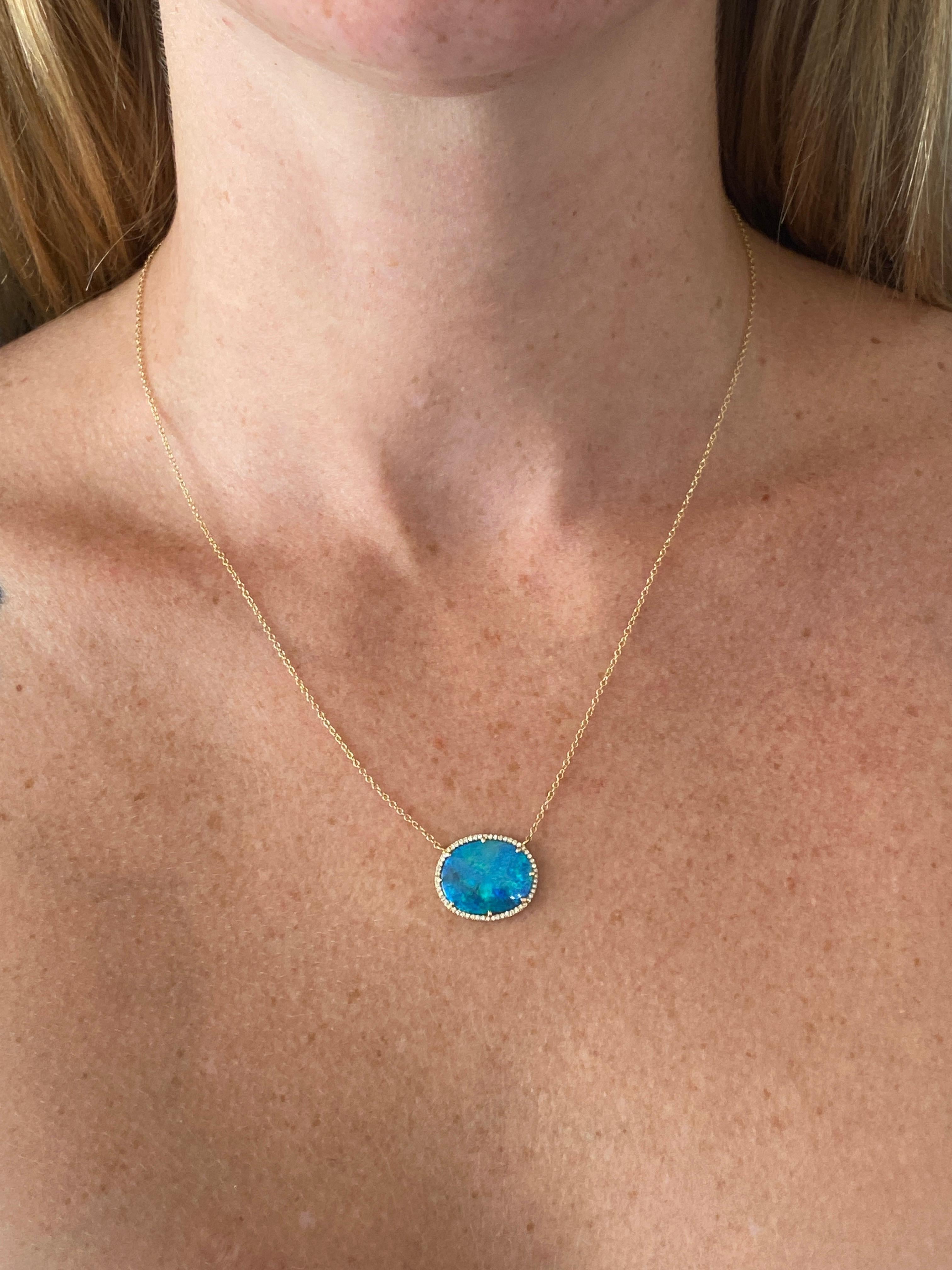 The genuine black opal has an intense blue color and is stunning on anyone's neck. The diamonds encircling the opal makes it even more intriguing. Encircled with the 14 karat yellow gold the color of the natural opal really pops! There is a total of