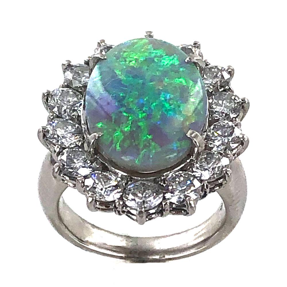 Beautiful fiery opal diamond estate ring fashioned in platinum. The 5.20 carat colorful opal is surrounded by 14 round brilliant cut diamonds weighing approximately 2.53 carat total weight. The brilliant diamonds are graded G-H/VS. The ring is