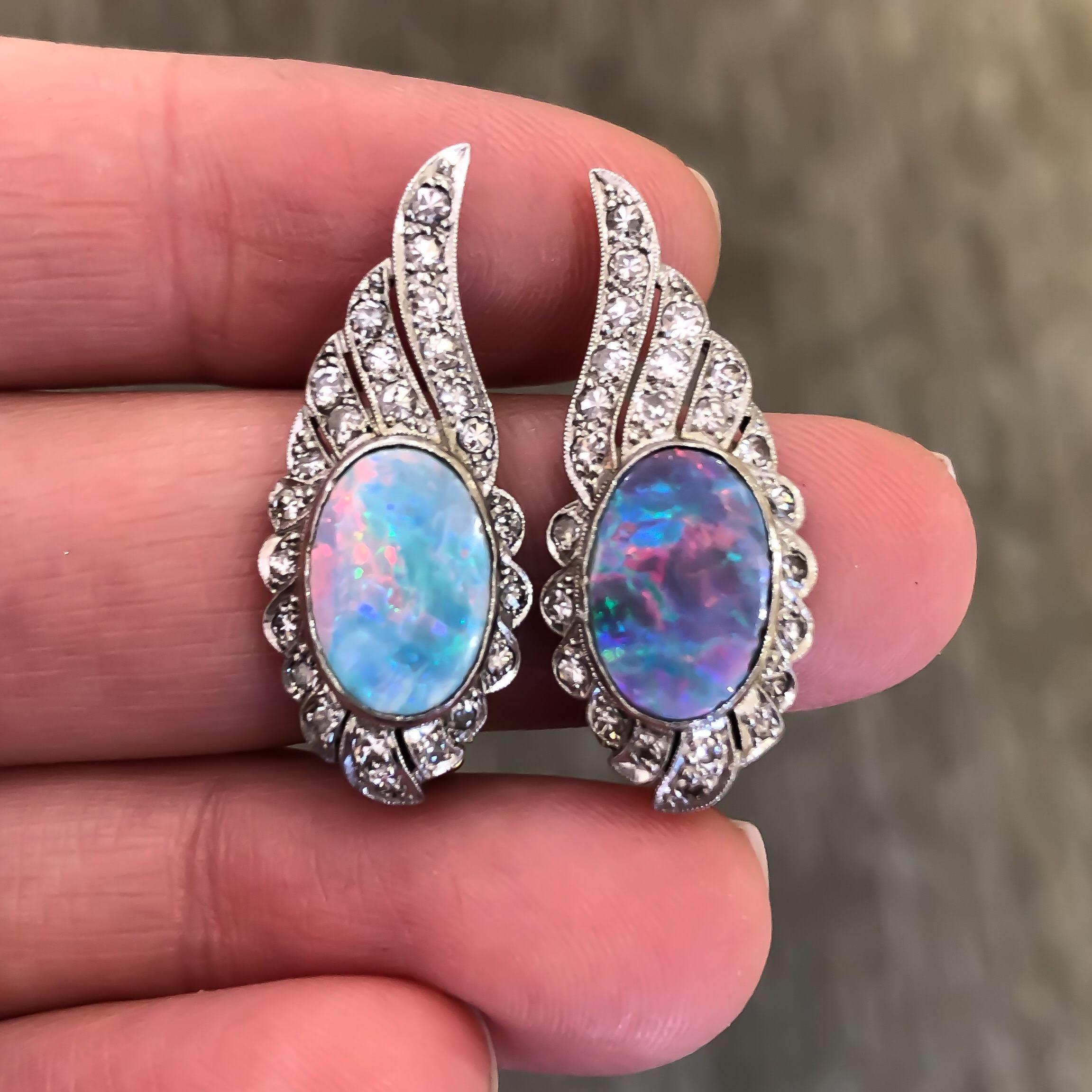 These stunning vintage doublet Australian opals are bright bluish green with flashes of red and yellow. They are securely bezel set into flattering platinum wing shaped clip earrings with bead set single cut diamonds with delicate milgrain design.