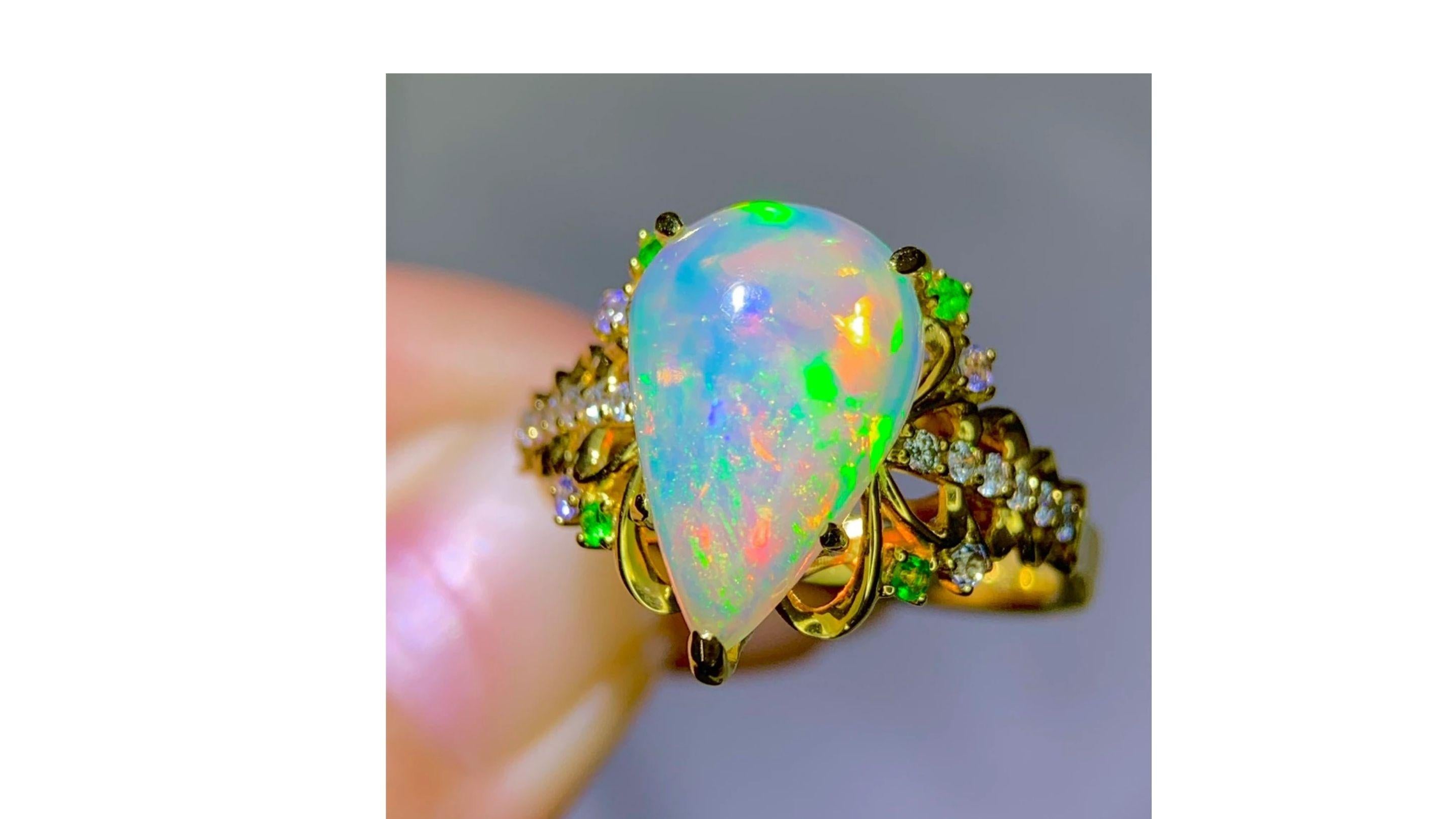 
This white Opal ring shows off bright colors  yellow green orange blue red and stands out and its a 3.22ct opal.  Diamonds are 0.22ct which are down each side of band and this is a Ethiopian opal and set in 18k Yellow gold. These are unique stones