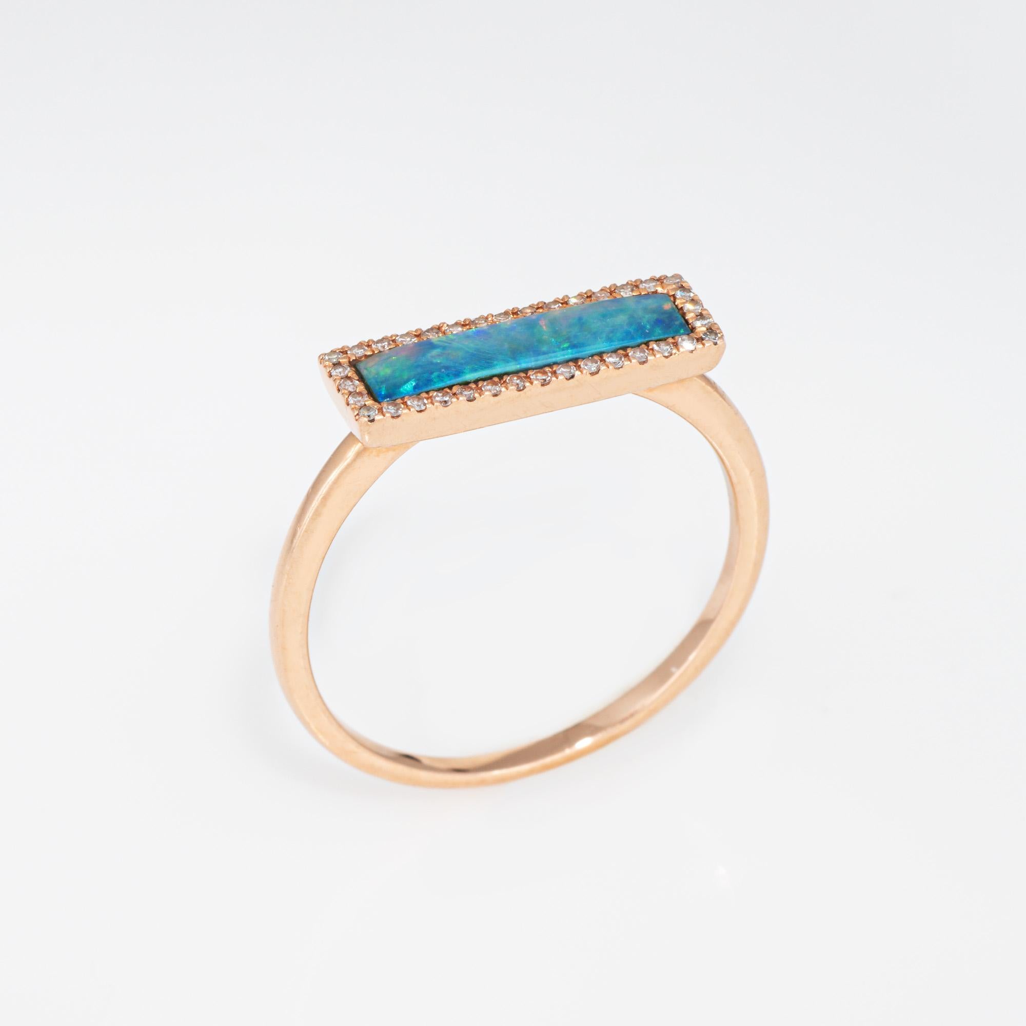 Stylish opal & diamond ring crafted in 14 karat rose gold. 

Opal measures 12mm x 3mm. Diamonds total an estimated 0.15 carats (estimated at I-J color and SI1-I1 clarity). The opal is in very good condition and free of cracks or chips. 

The east to