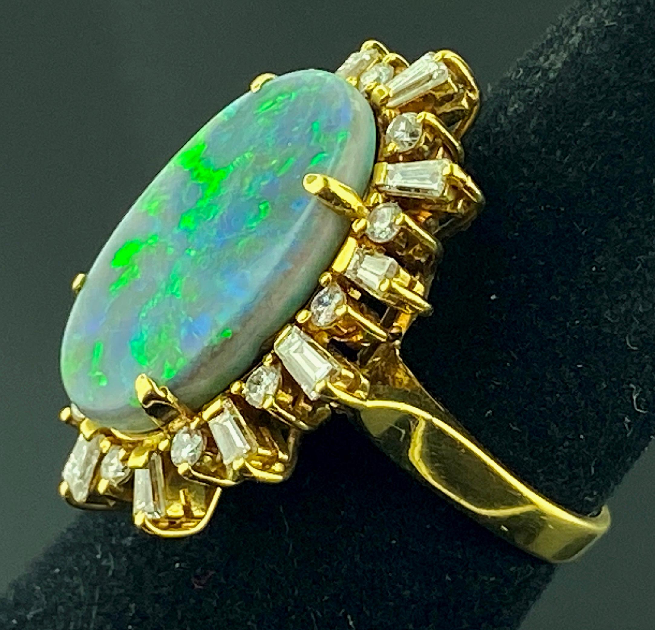Set in 18 karat yellow gold is a Natural Boulder Opal, measuring 11.5 x 18.88 mm, surrounded with 12 tapered baguette cut diamonds for a weight of 0.50 carats, plus 12 round brilliant cut diamonds with a weight of 0.50 carats.  Total diamond weight