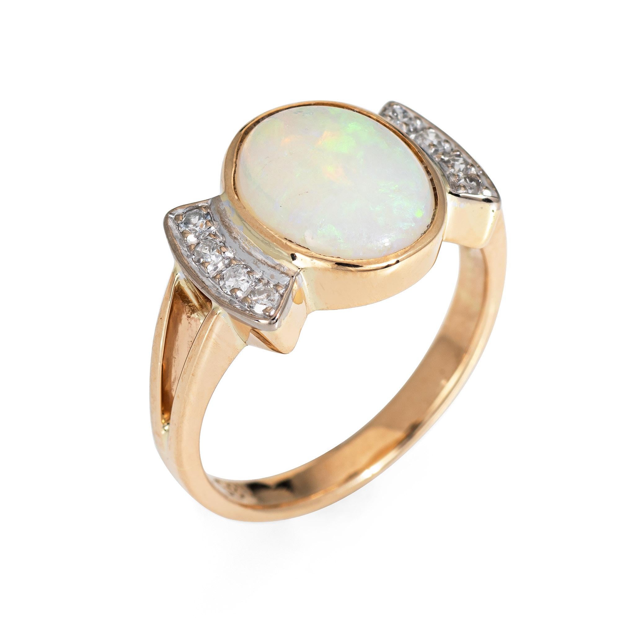 Stylish vintage opal & diamond ring (circa 1970s to 1980s) crafted in 14 karat yellow gold. 

Cabochon cut opal measures 10mm x 8mm (estimated at 3 carats) is accented with eight estimated 0.01 carat diamonds. The total diamond weight is estimated