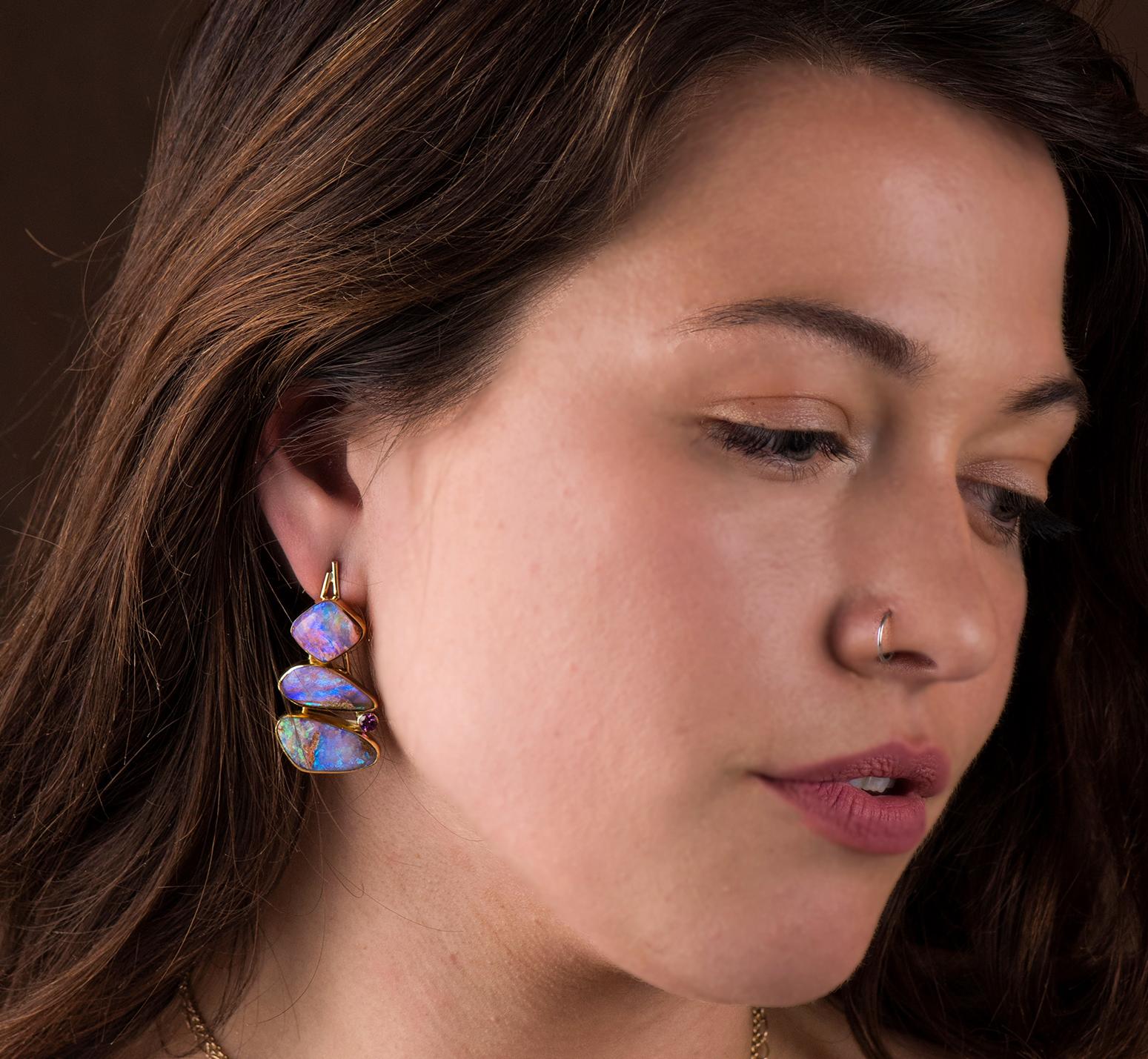 Opal is found in many type of matrix's.  These earrings are opal in petrified wood!  Amazing really.  The color and depth of the opal is lovely, framed in high carat 22k gold with 18k gold accents.  The grape garnet pulls a bit of the purple out of
