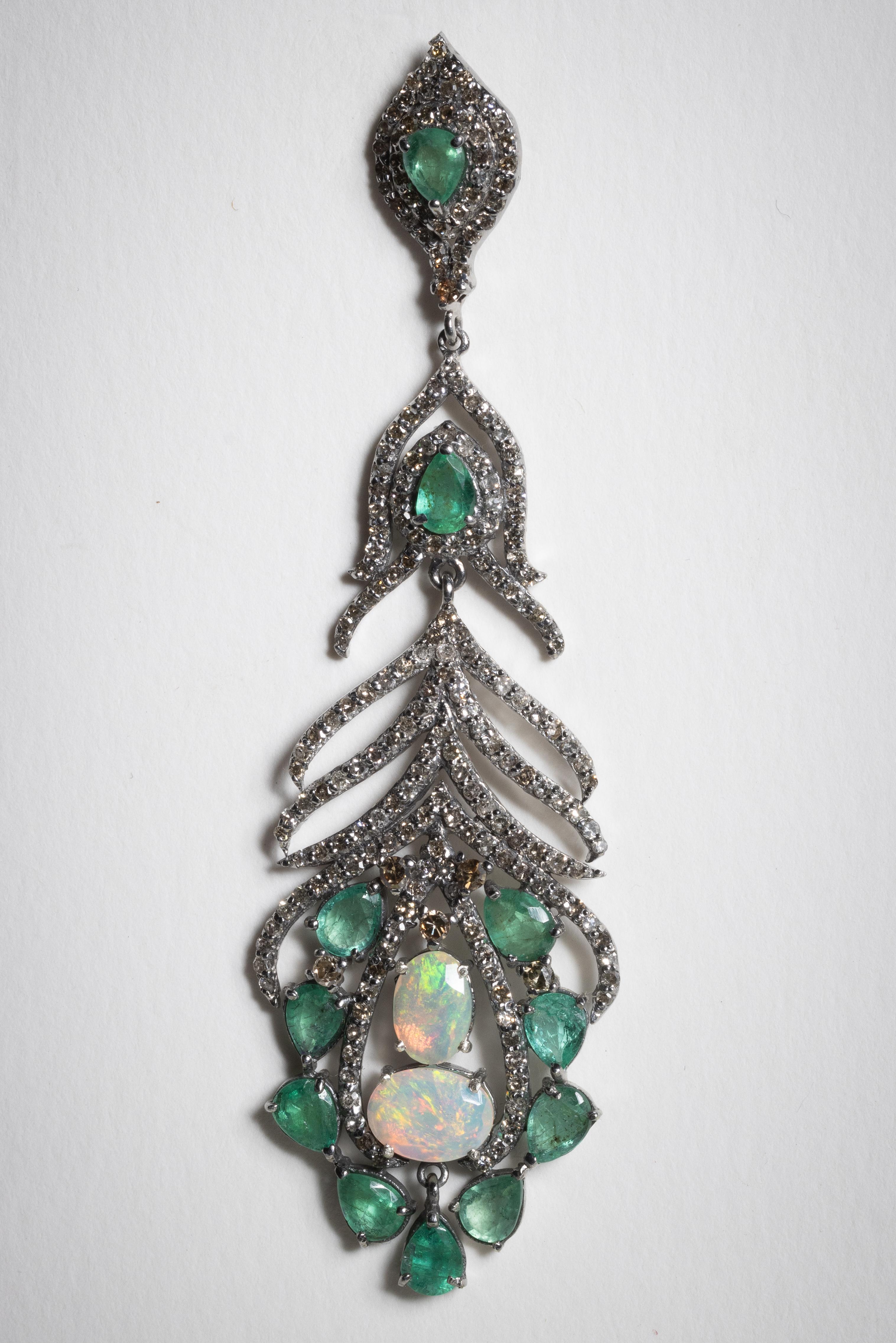 A magnificent pair of chandelier earrings in a feather-like motif. A cluster of oval opals at the bottom surrounded by faceted, pear-shaped emeralds; along with round, brilliant cut diamonds in a pave` setting.  All set in an oxidized sterling