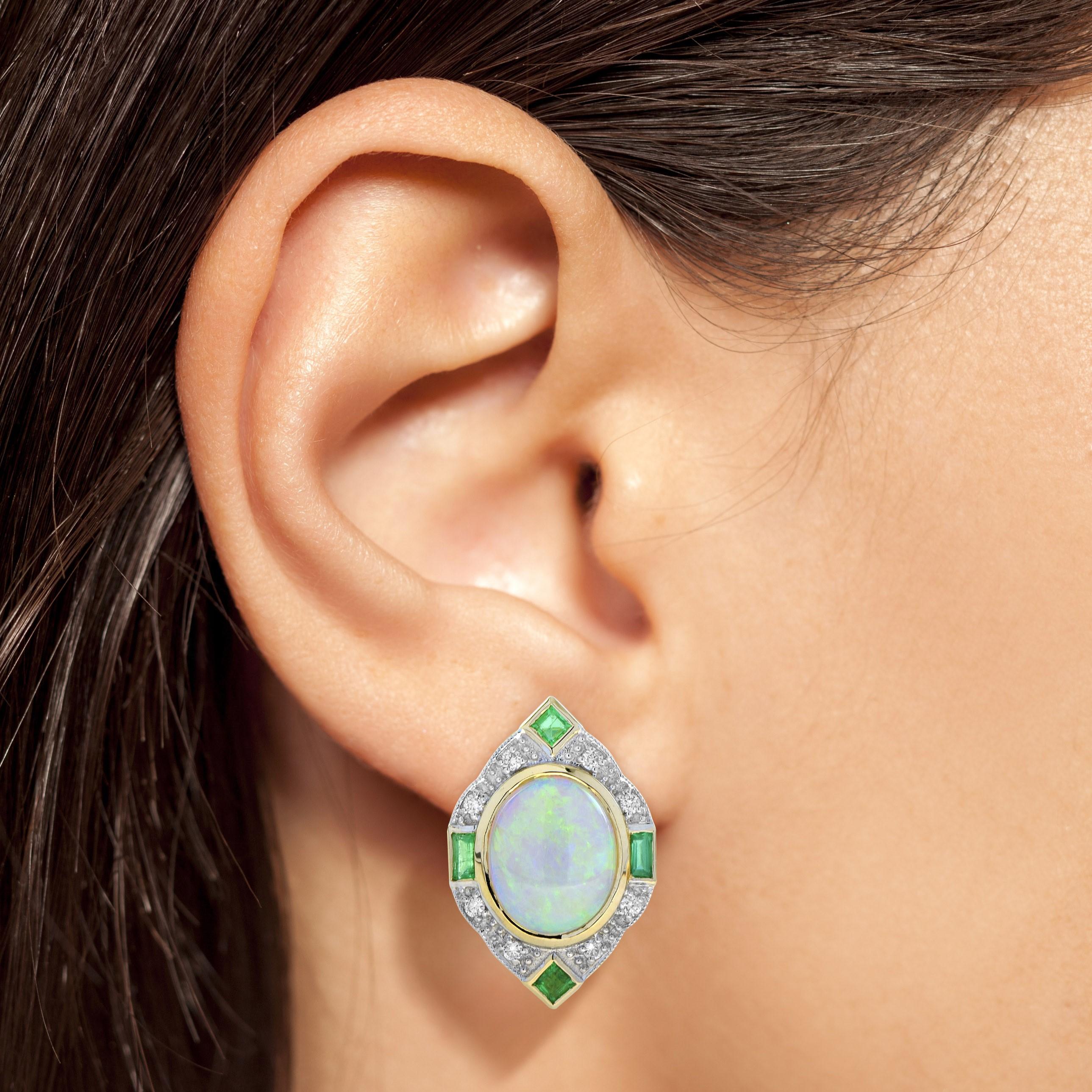Crafted in 14k yellow gold, this fanciful, Art Deco inspired earrings sees a raised an opulent total of 4.20 carat oval opal surrounded by sparkling round diamonds and emeralds. This charming piece is a winsome adornment perfect to mark a milestone