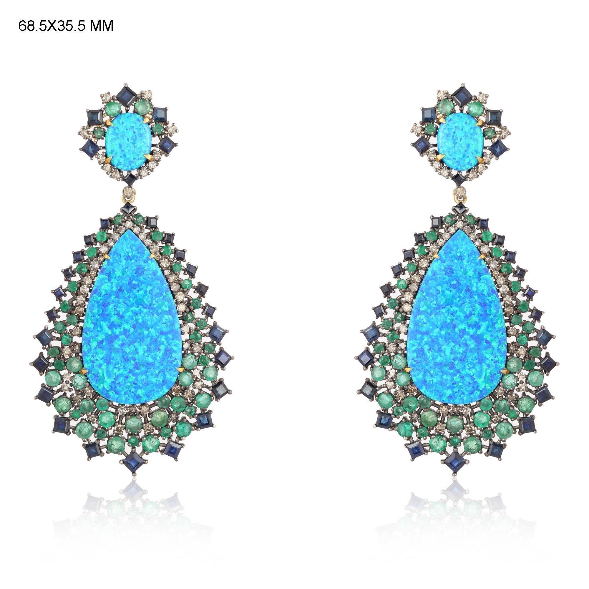 These stunning earrings are crafted in 18-karat gold and sterling silver. It is hand set in 11.2 carats opal doublets, 6.02 carats emerald, 5.37 carats blue sapphire and 1.65 carats of diamonds. See other opal pieces that compliments with these