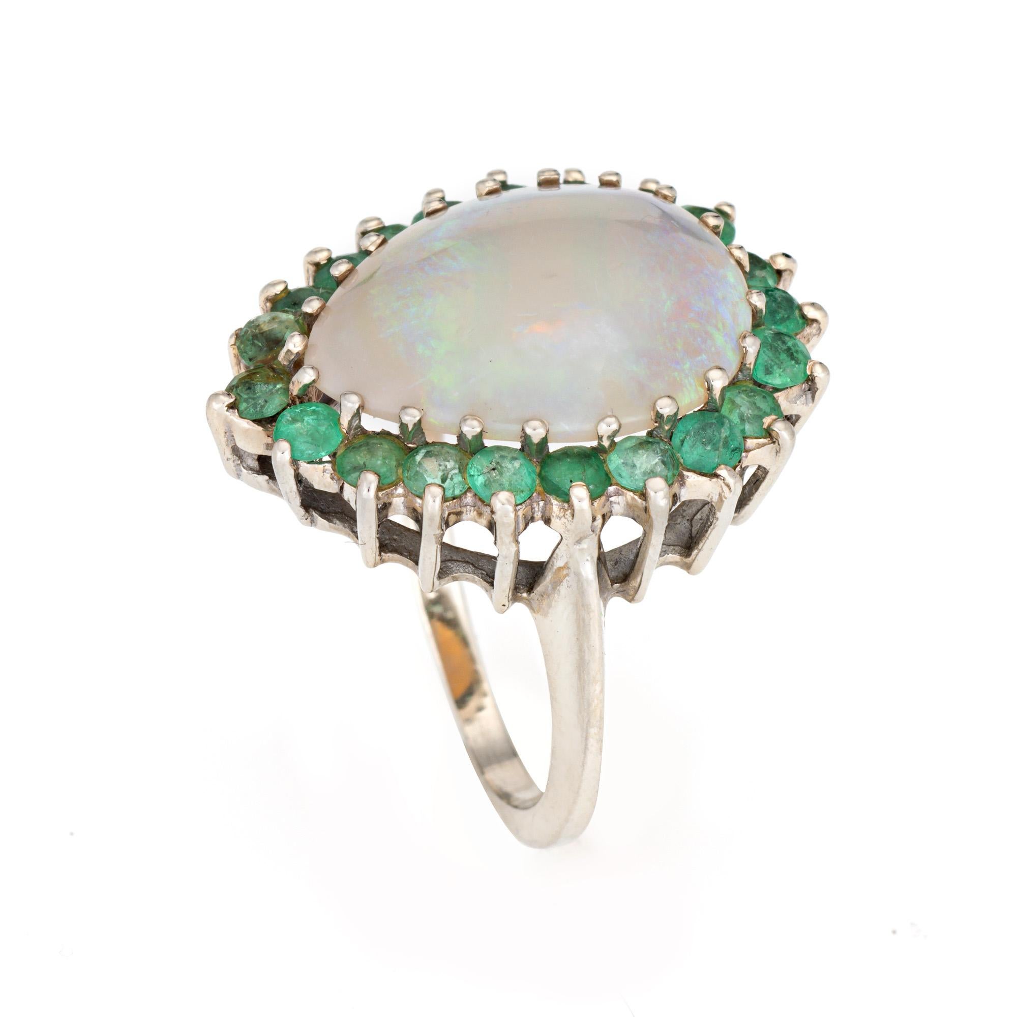 Stilvoller Ring mit Opal und Smaragd aus 14 Karat Weißgold (ca. 1980er bis 1990er Jahre).

Der Opal im Cabochon-Schliff misst 17 mm x 13 mm. 21 Smaragde messen jeweils ca. 2 mm. Der Opal ist in sehr gutem Zustand und frei von Rissen oder