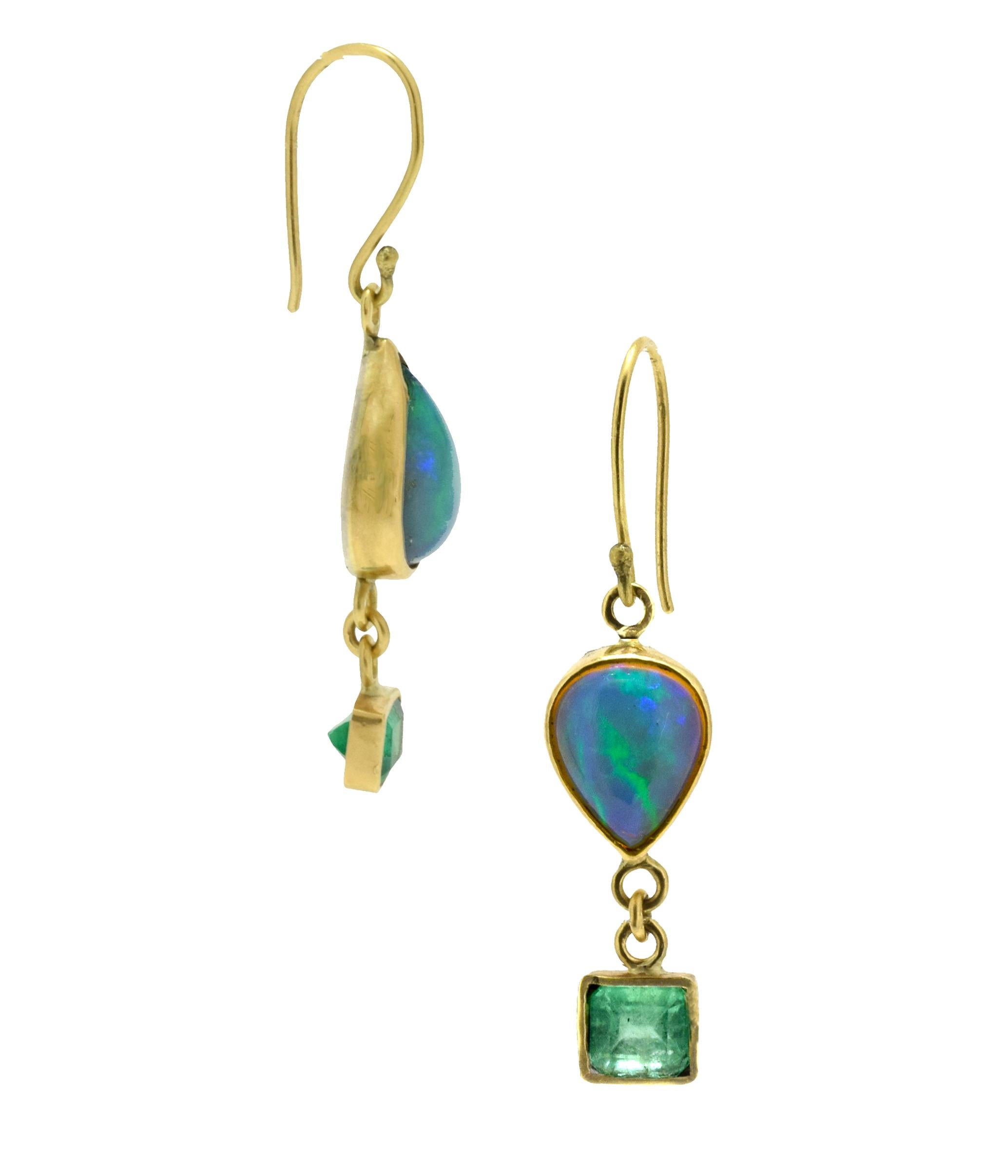 Ethiopian teardrop opals (4.67tcw) are paired with rectangular emeralds (3tcw) in these asymmetrical drop earrings. These opals have a lot of green/blue fire in them that glows when the light hits them. Bezel set in 18k recycled gold with a sterling