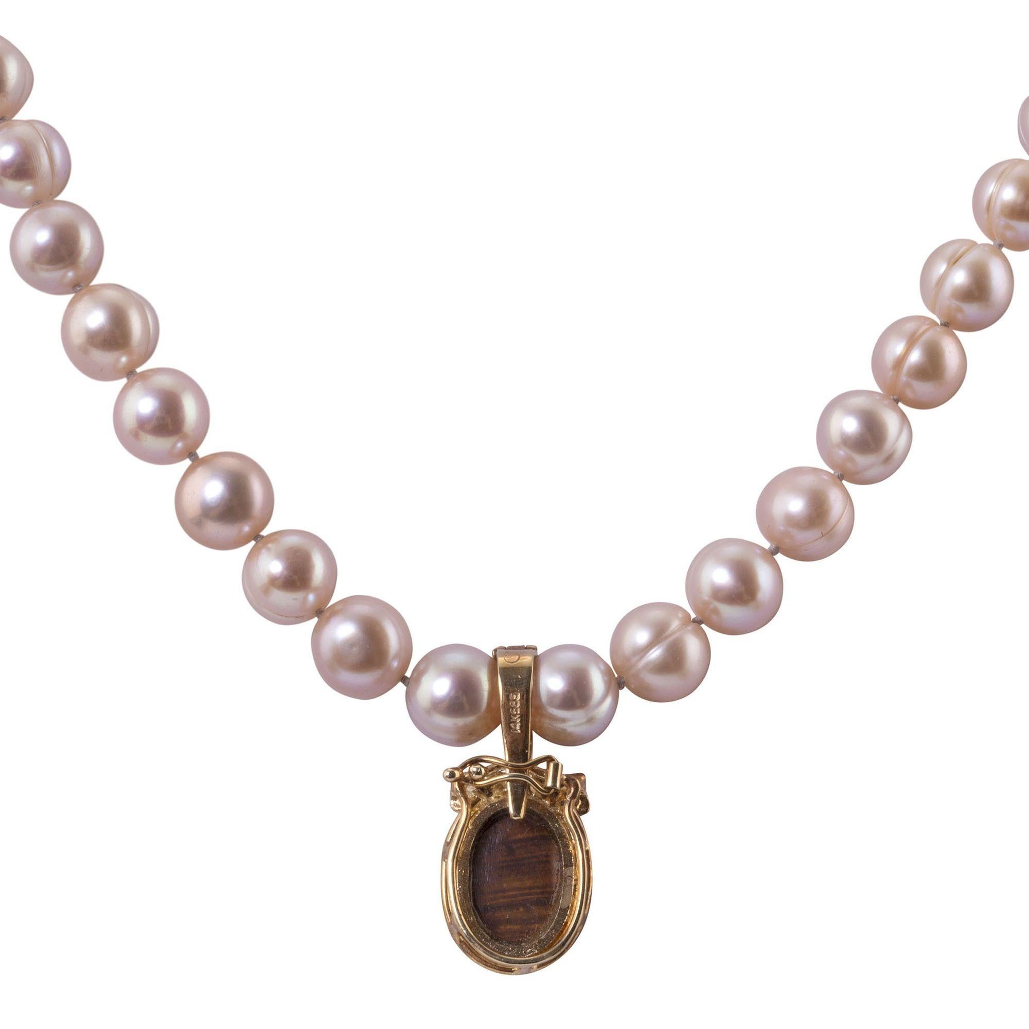 Estate opal enhancer pendant on pearl necklace. This necklace features 50 light rose colored cultured pearls at 8.5mm. The necklace comes with a 14 karat yellow gold enhancer pendant with a 3 carat opal and .08 carat total weight in accent diamonds.