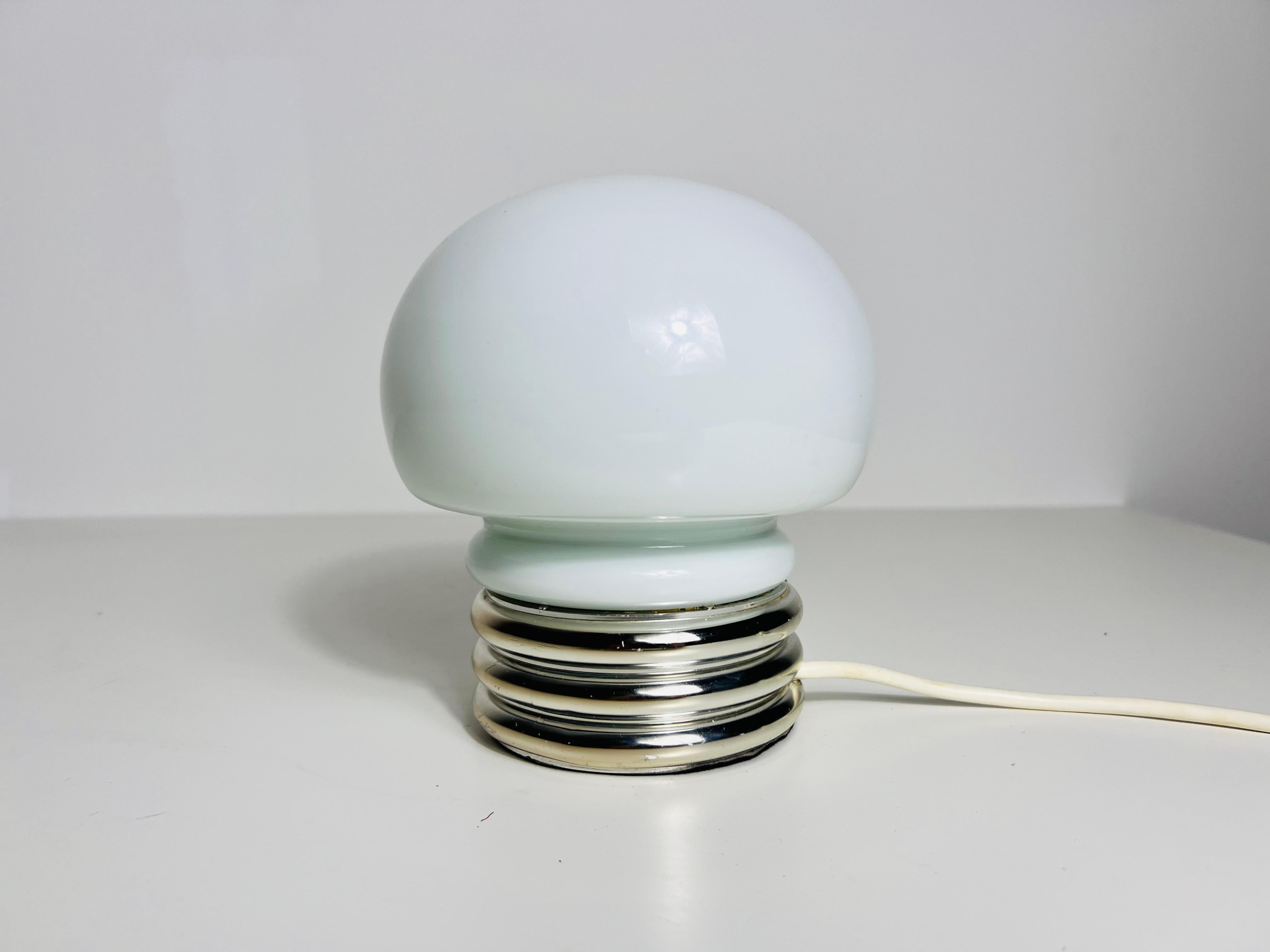 This sophisticated table lamp from the 1970s embodies the iconic space-age aesthetic, adding a touch of retro charm to any interior. Its minimalist yet refined design ensures it complements a wide range of décor styles.

The lamp features a large,