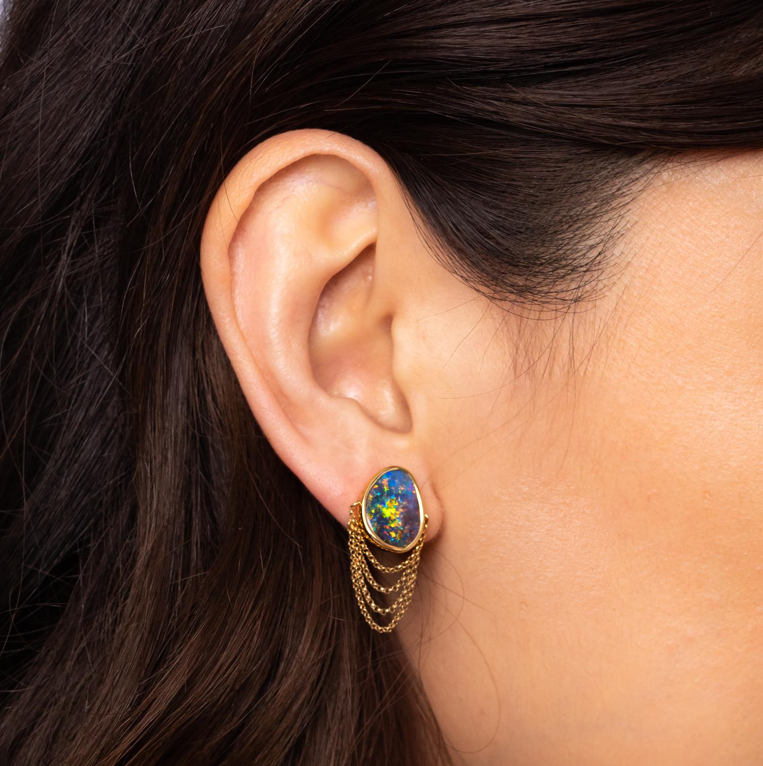 “La Vida Dulce” opal earrings seduce with vibrant colours and the alluring sway of delicate gold chains. Boulder opals (8.21ct) are set in 18K yellow gold – the host rock peeping through adds to the rawness of the piece and gives it an edge. A