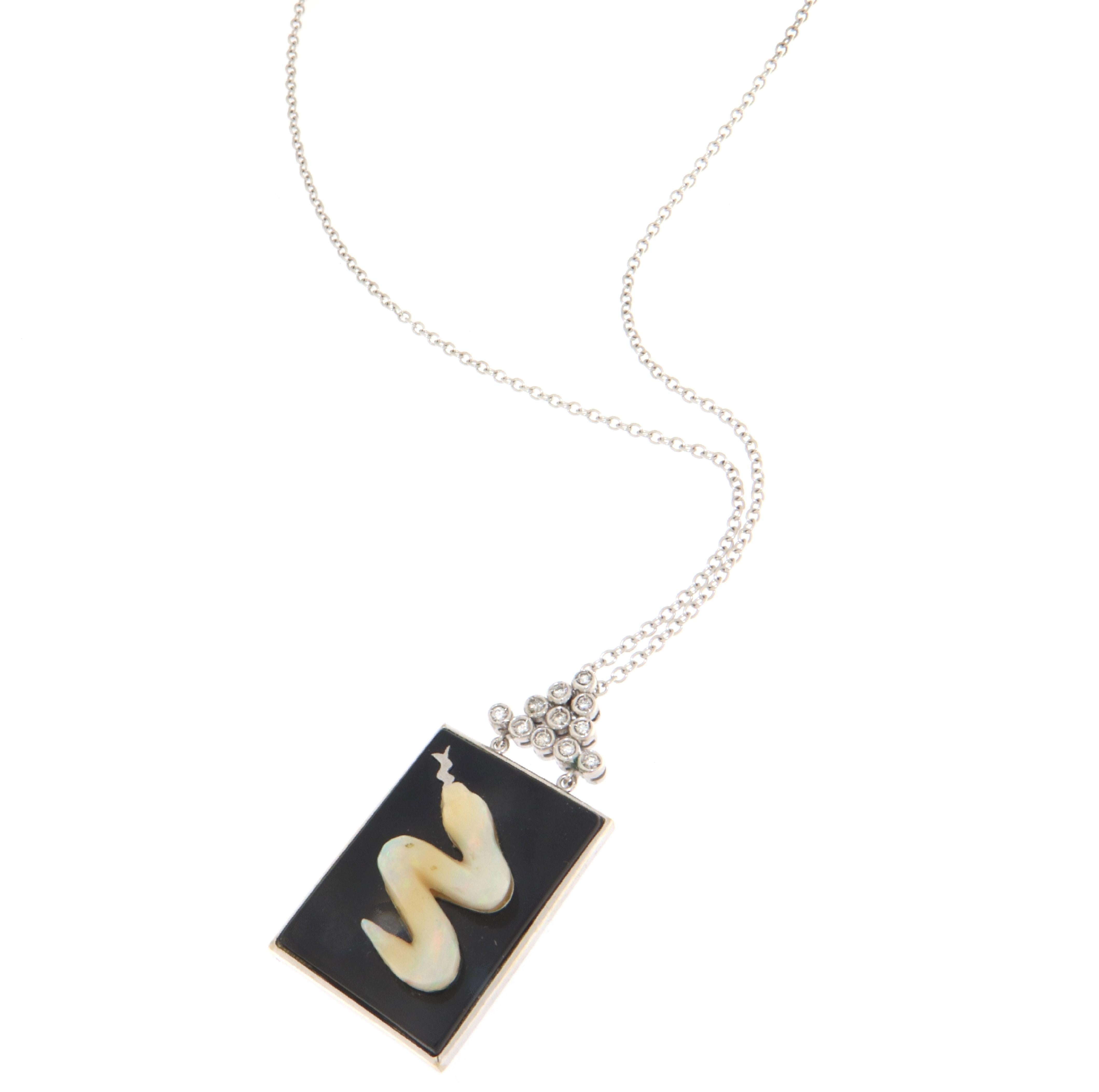 This stunning 18-karat white gold necklace features a pendant that elegantly combines timeless design with exquisite craftsmanship. The pendant boasts a sleek onyx plate that provides a dramatic backdrop for the captivating opal snake that