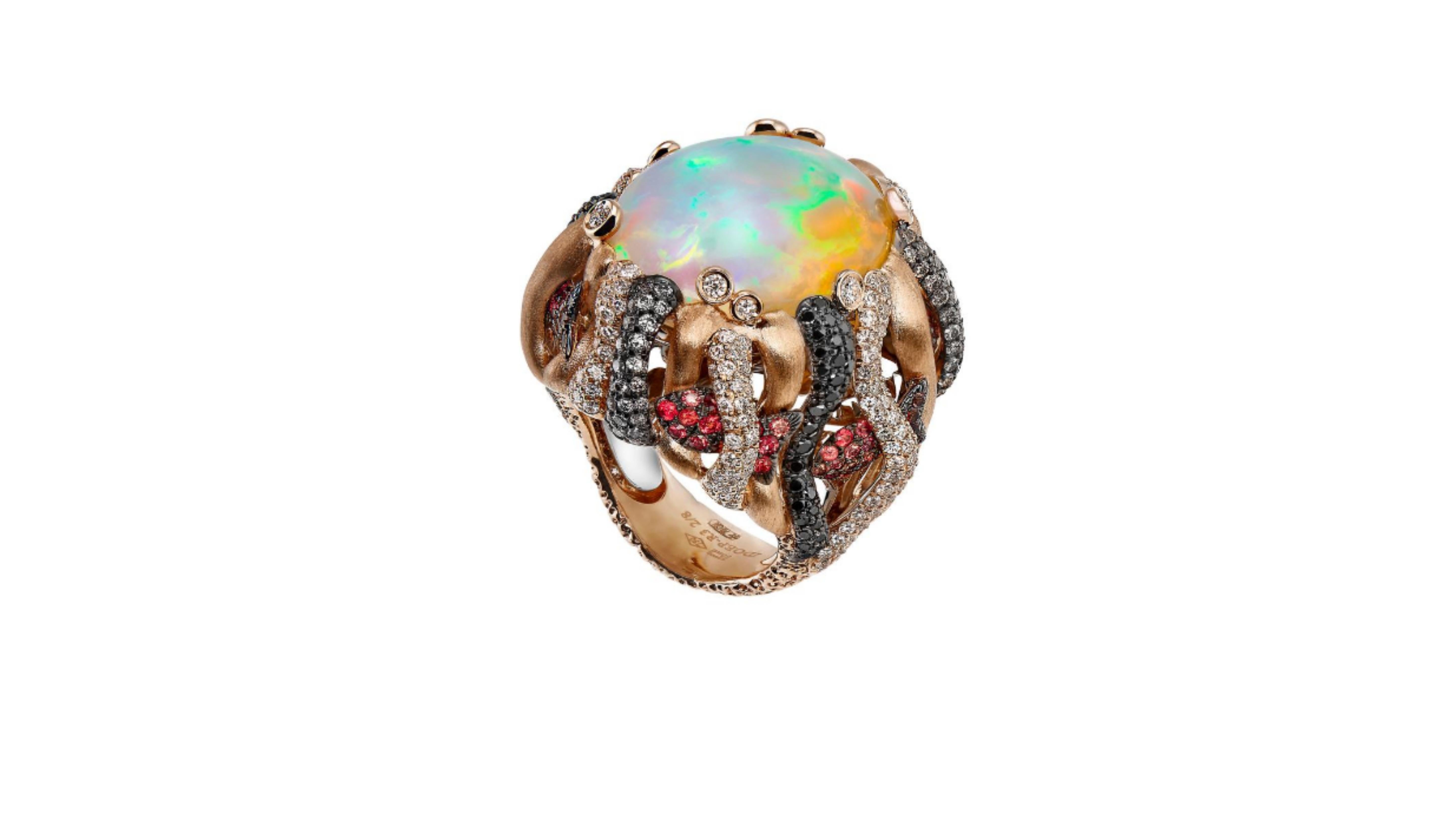
This is a unique Ethiopian Opal Ring with Paraiba Tourmaline  Black Diamonds and White ones and also Orange Sapphire  stones . So really you are getting a mix of different kinds . Set in 18 Karat Yellow Gold .   

The story of this neon-bright