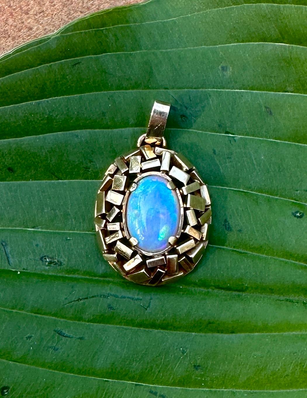 This is an absolutely gorgeous Fire Opal Pendant in a stunning Retro setting in 14 Karat Gold.  The extraordinary oval cabochon opal is approximately 14.5mm by 10mm by 3mm.  The opal has magnificent fire with an exuberance of blue, green, red and