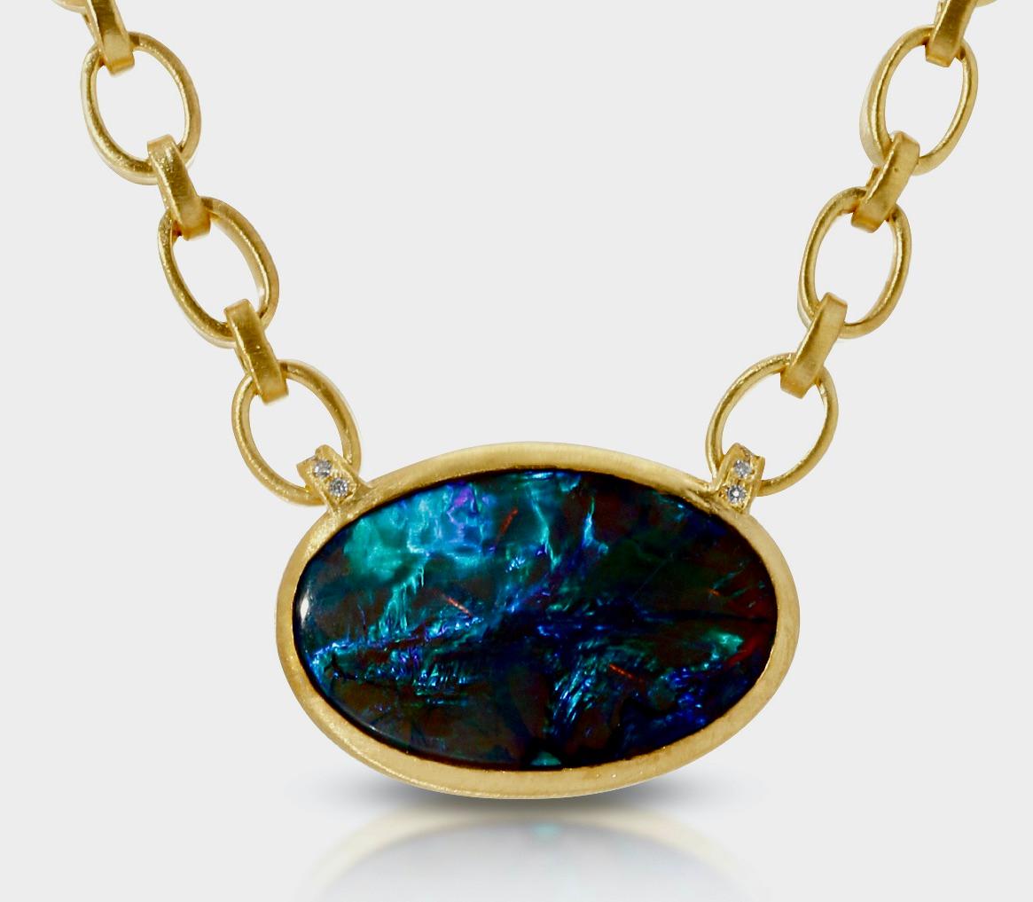 This 5.20ct Australian Crystal Opal is Bezel Set in 18K Yellow Gold. .08ct Pave vs quality Diamonds adorn the Loops attaching the Opal to the 17in. Handmade Chain with vs quality Diamond Pave set into the tips of the Toggle closure. This piece is