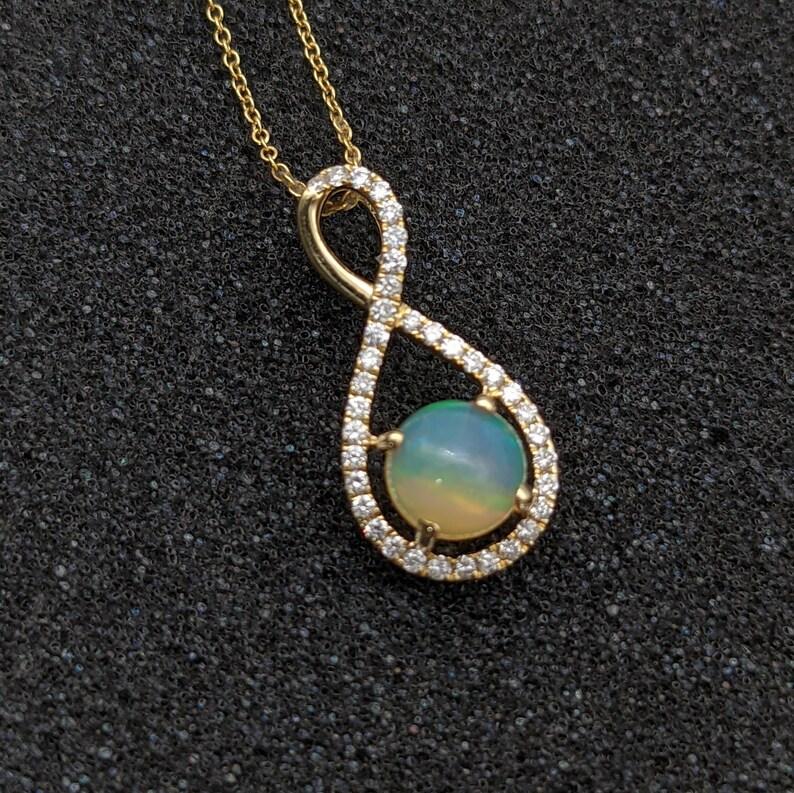 Specifications:

Item Type: Pendant
Stone type: Opal 
Weight: 0.7 ct
Shape: Round
Size: 6mm
Treatment: Untreated
Hardness: 5-6.5

Metal: 14k/1.3g
Diamond: 36/0.17 cttw

This pendant is made with solid 14k Gold and natural Earth mined SI/GH