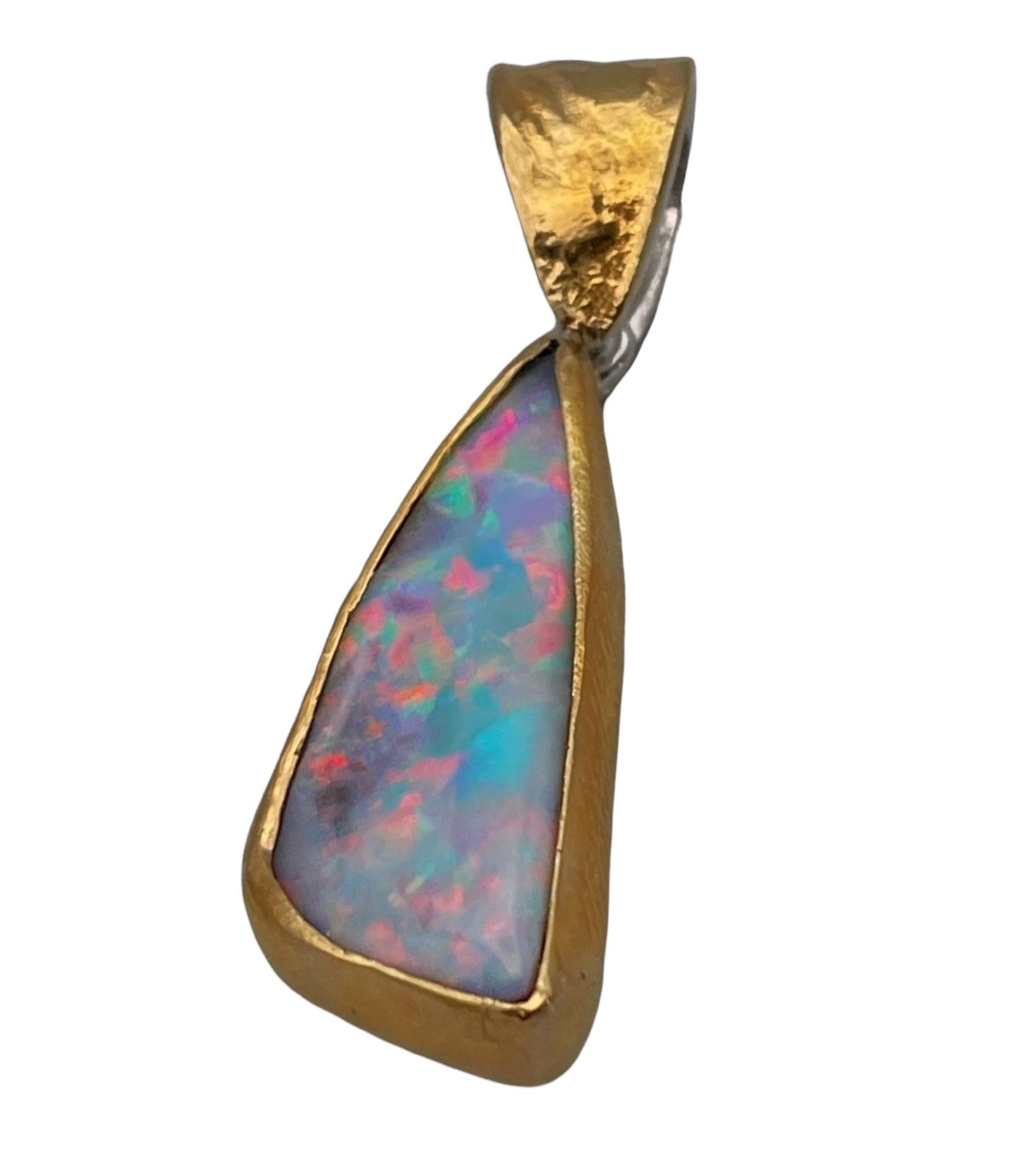 This is a gorgeous little boulder opal pendant with bright colourful flashes and movement. It has been carefully handcrafted and set in 22 karat yellow gold. It is backed with sterling silver where it has a large deep British hallmark stamped. The