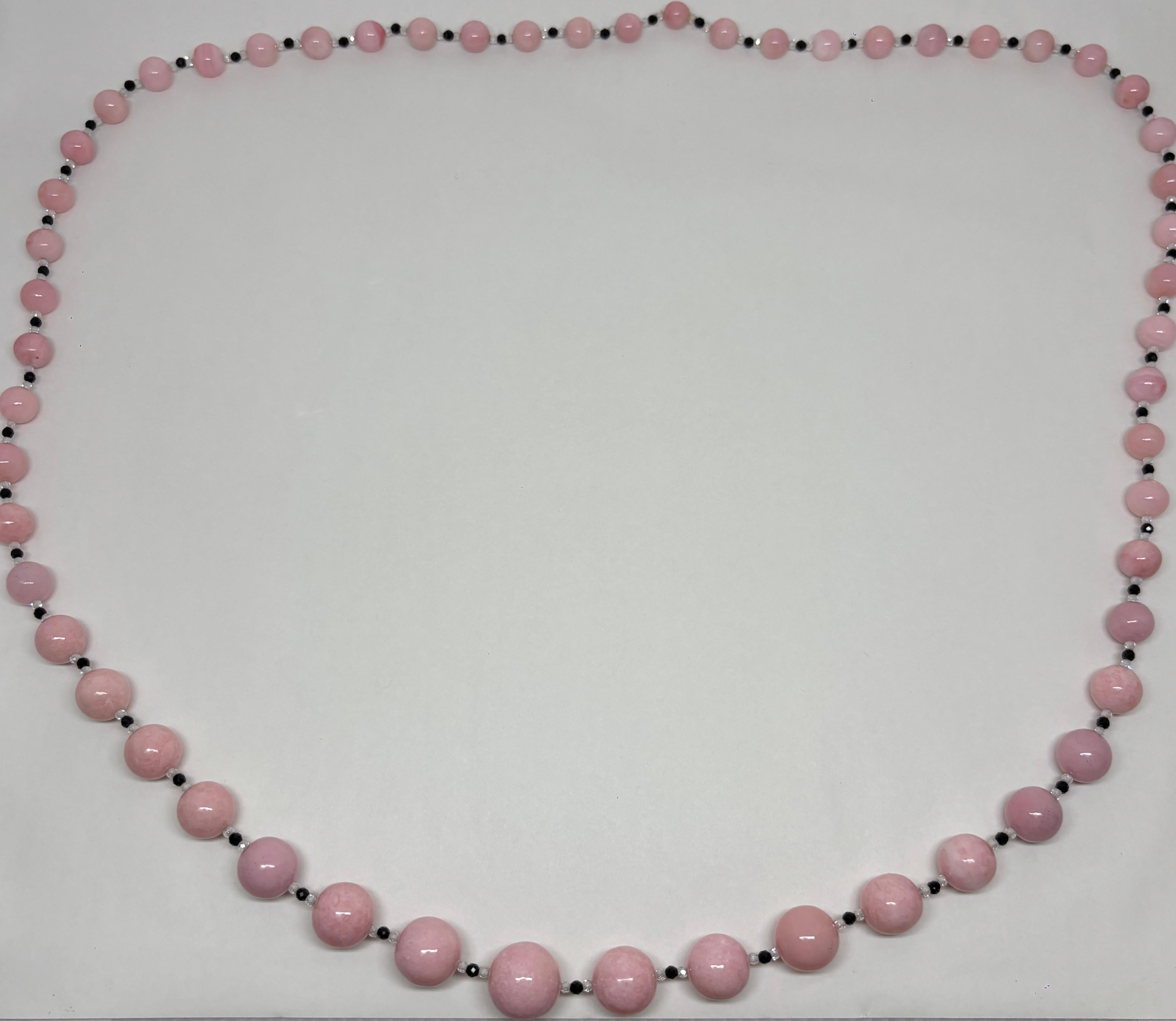 Ce captivant collier à une ligne de 39 pouces met en valeur une opale rose douce de Mixco, élégamment associée à un onyx noir audacieux et à des perles de cristal scintillantes. 

Le rose doux de l'opale dégage une énergie calme et aimante, tandis