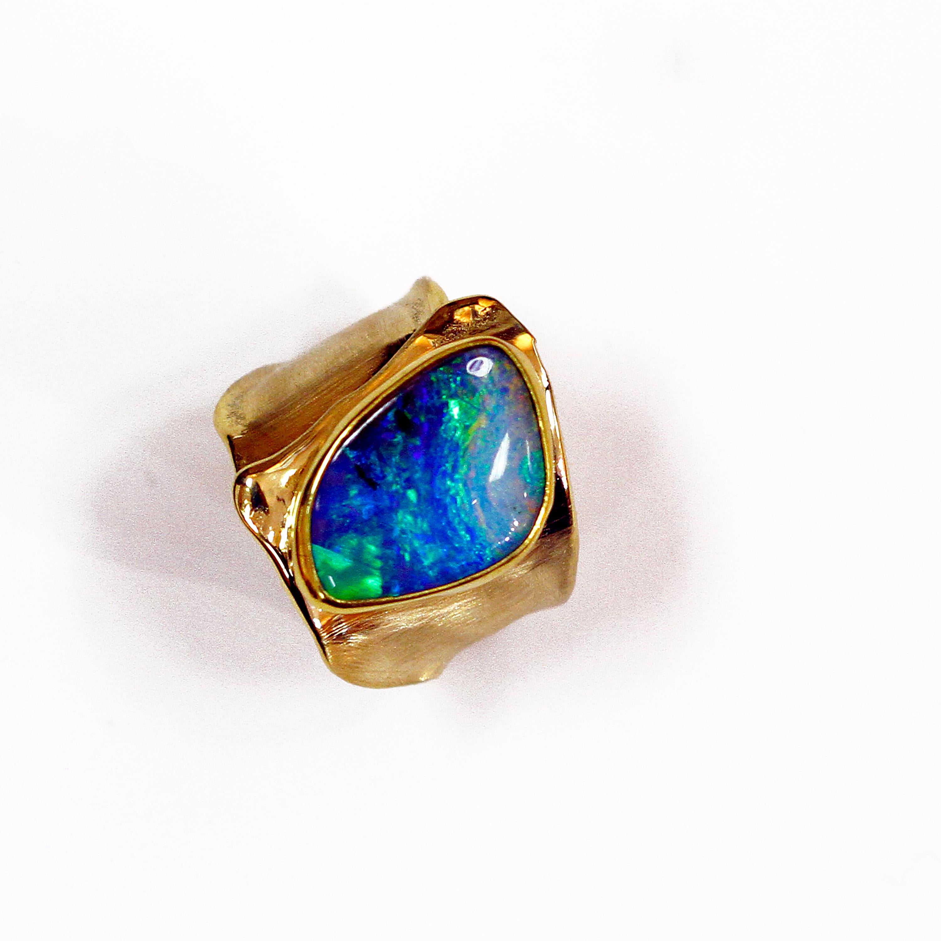Every boulder opal is unique. The variety of color play in an opal is extraordinary. This boulder opal ring is bright with flash, and with every hue of blue, green and a brush stroke of pink! I have textured the 18k gold while leaving the gold edges