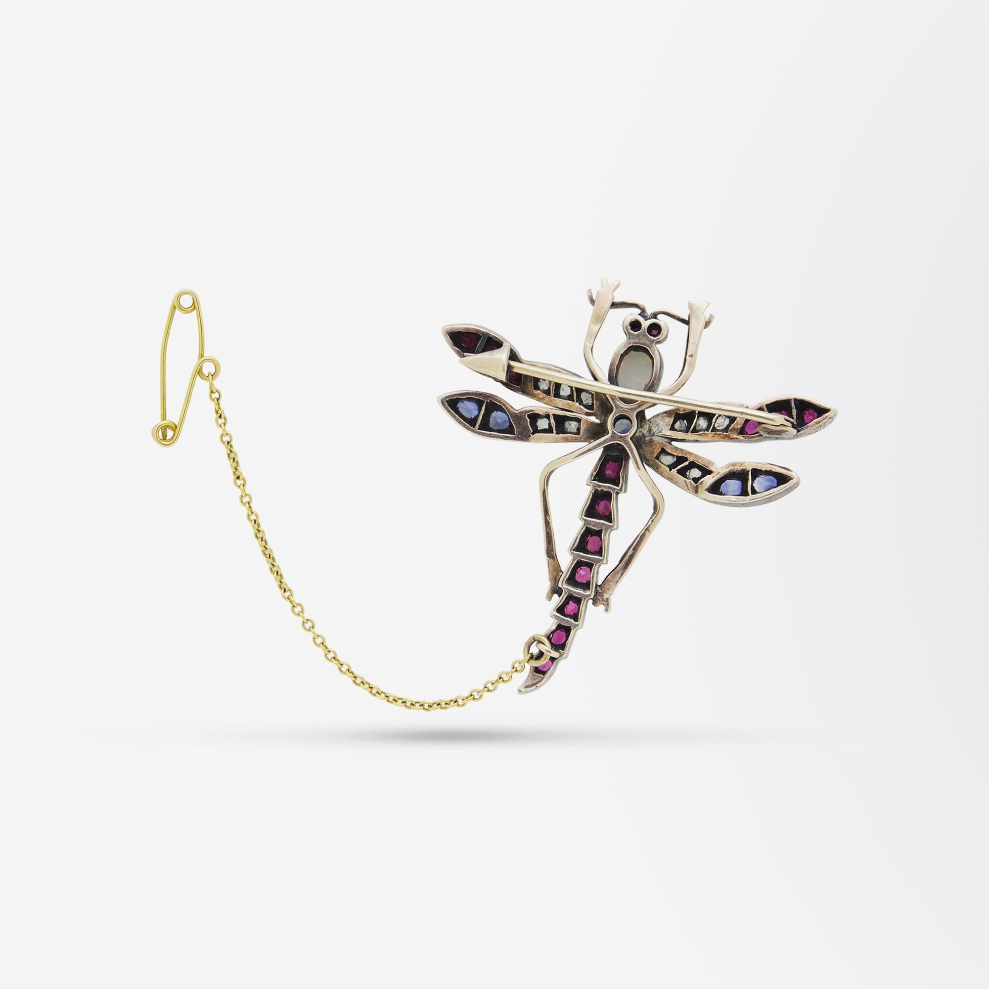 A fine Victorian era pin in the form of a dragonfly. The piece is constructed out of 9 karat rose gold which has a rich patina that has been set with Ceylon sapphires, Thai rubies and rose cut diamonds. The head of the dragonfly is set with a single