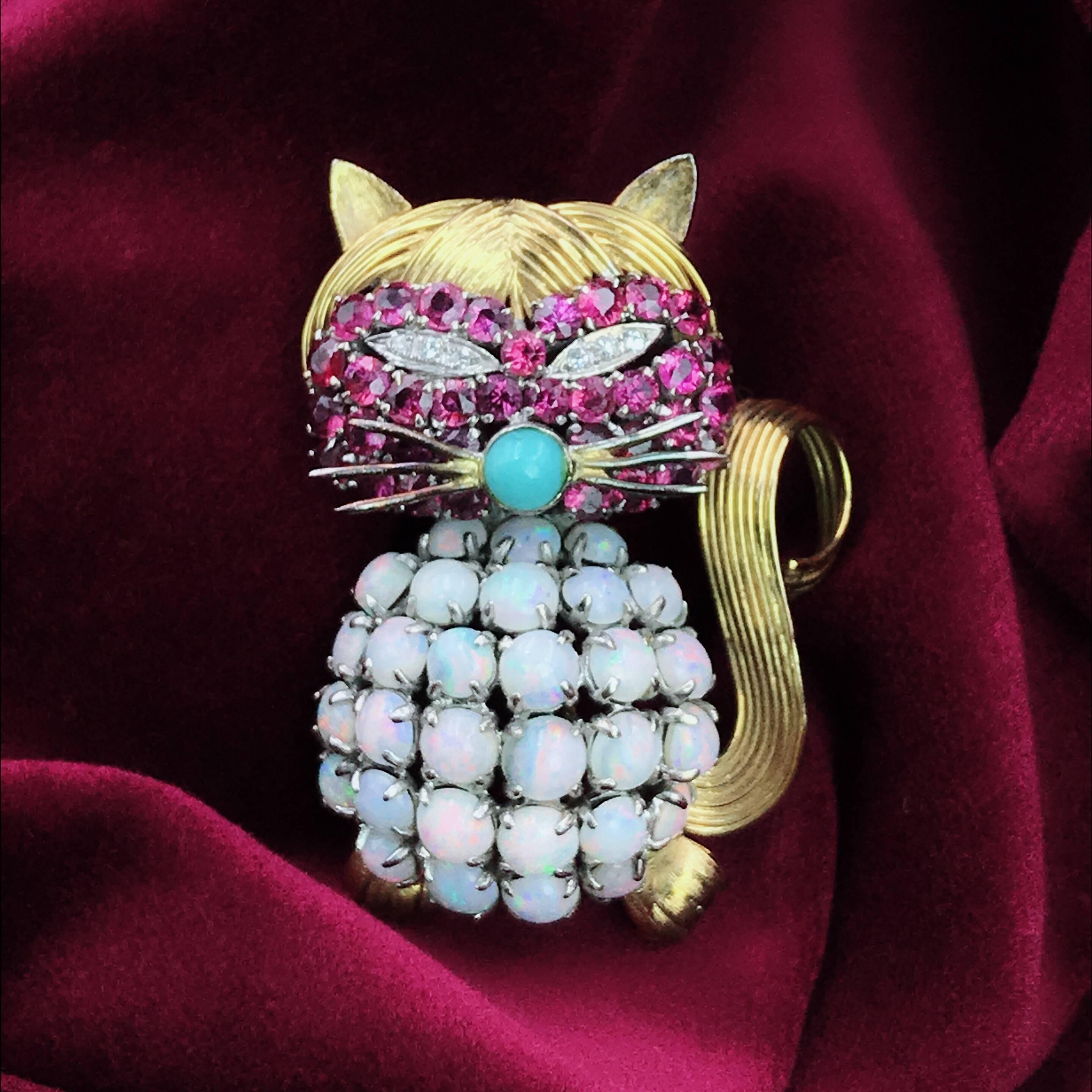 Opal Ruby Diamond and Turquoise Cat Pin. Crafted out of 14K yellow gold, with a belly of round opal cabochons, round-cut rubies on the face, weighing approximately 2.55 carats, round-cut diamonds for the eyes and turquoise for the nose; measures