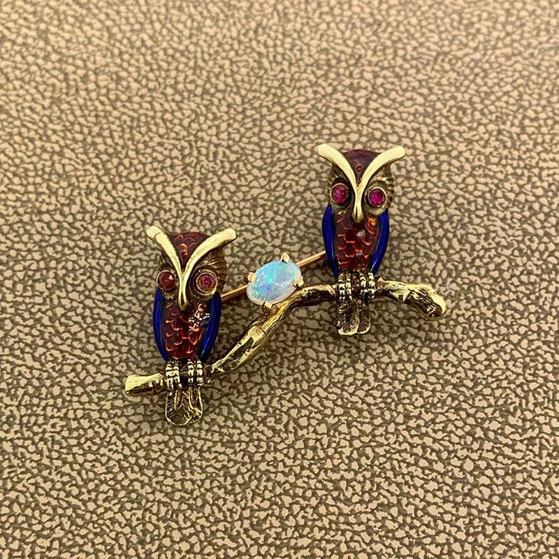 A small yet detailed brooch of two hand painted enameled owls sitting on a branch. Made in 14k gold, the two owls have rubies as eyes with one opal set in between them.

 

Length: 2.3 inches