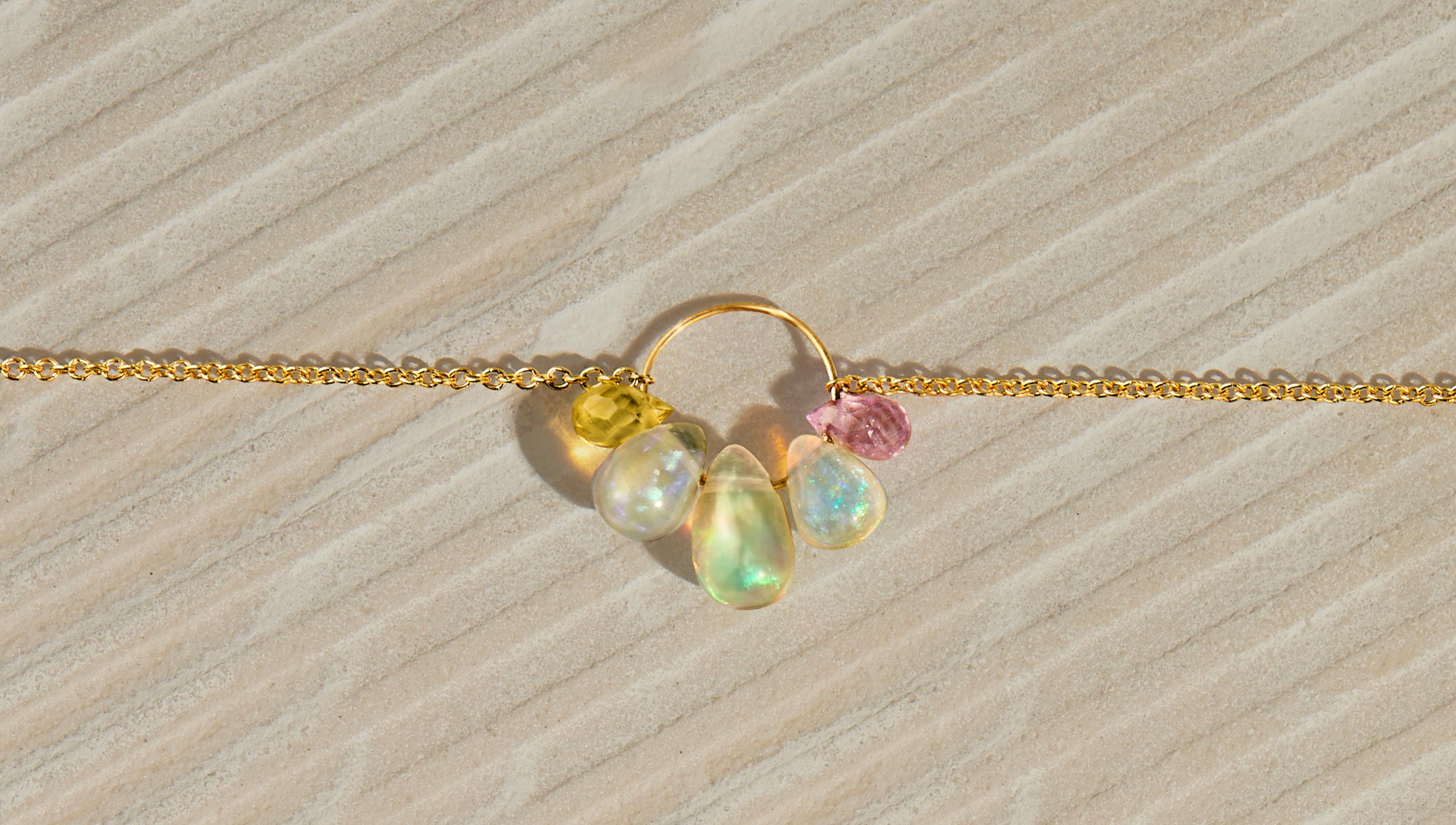 This delicate chain necklace in solid 18 karat gold features a central cluster of opal and sapphire briolettes.  Arrayed on a fine hoop are three smooth Ethiopian opal briolettes of graduated size along with one faceted yellow sapphire briolette and