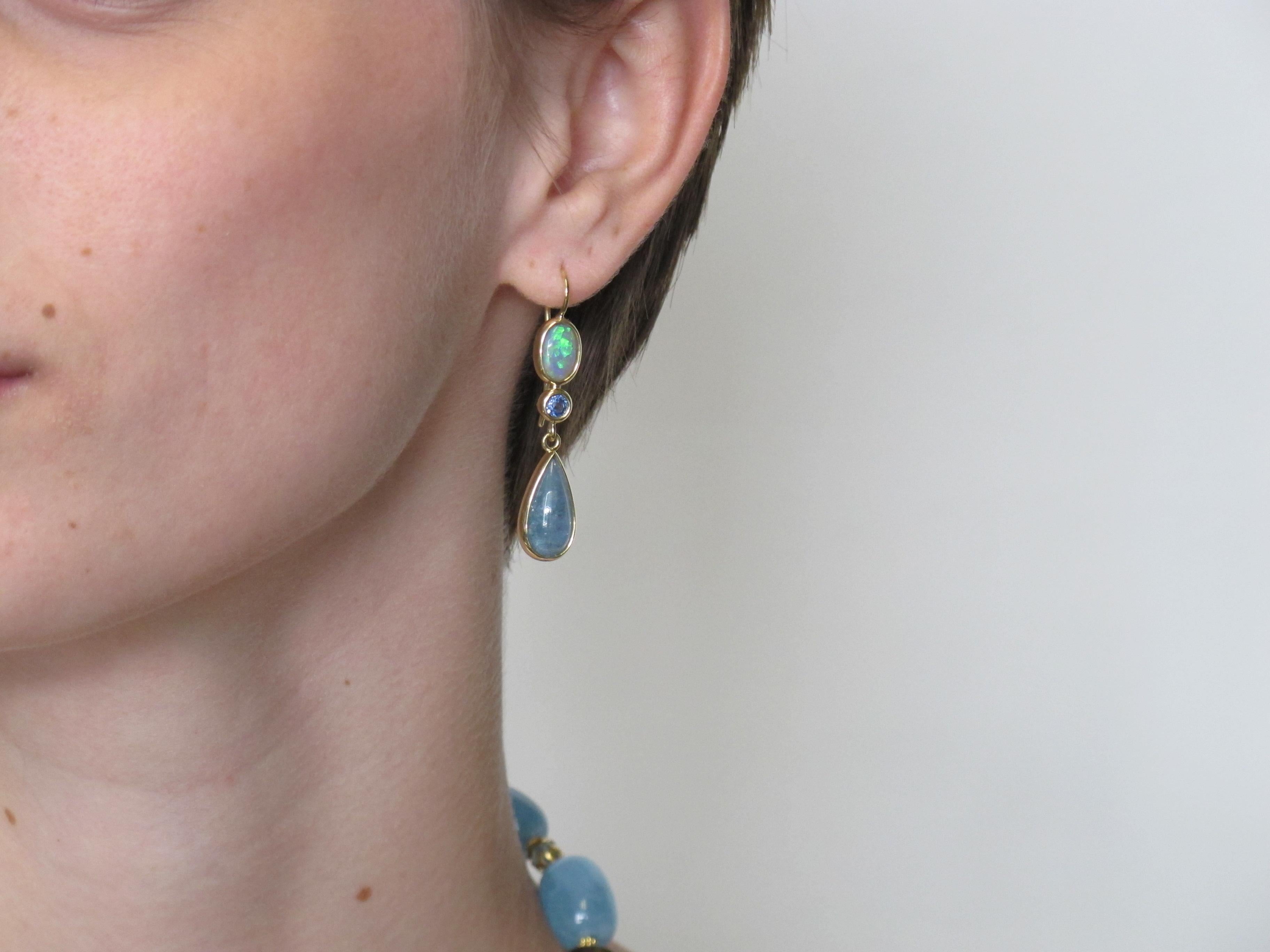 These pretty dangle earrings are one-of-a-kind. Their masterful mixture of gemstones speaks to the level of sophistication and knowledge of our designers.  Two opals, (1.91 carats total) are combined with two round sapphires, (3.95 carats total) and