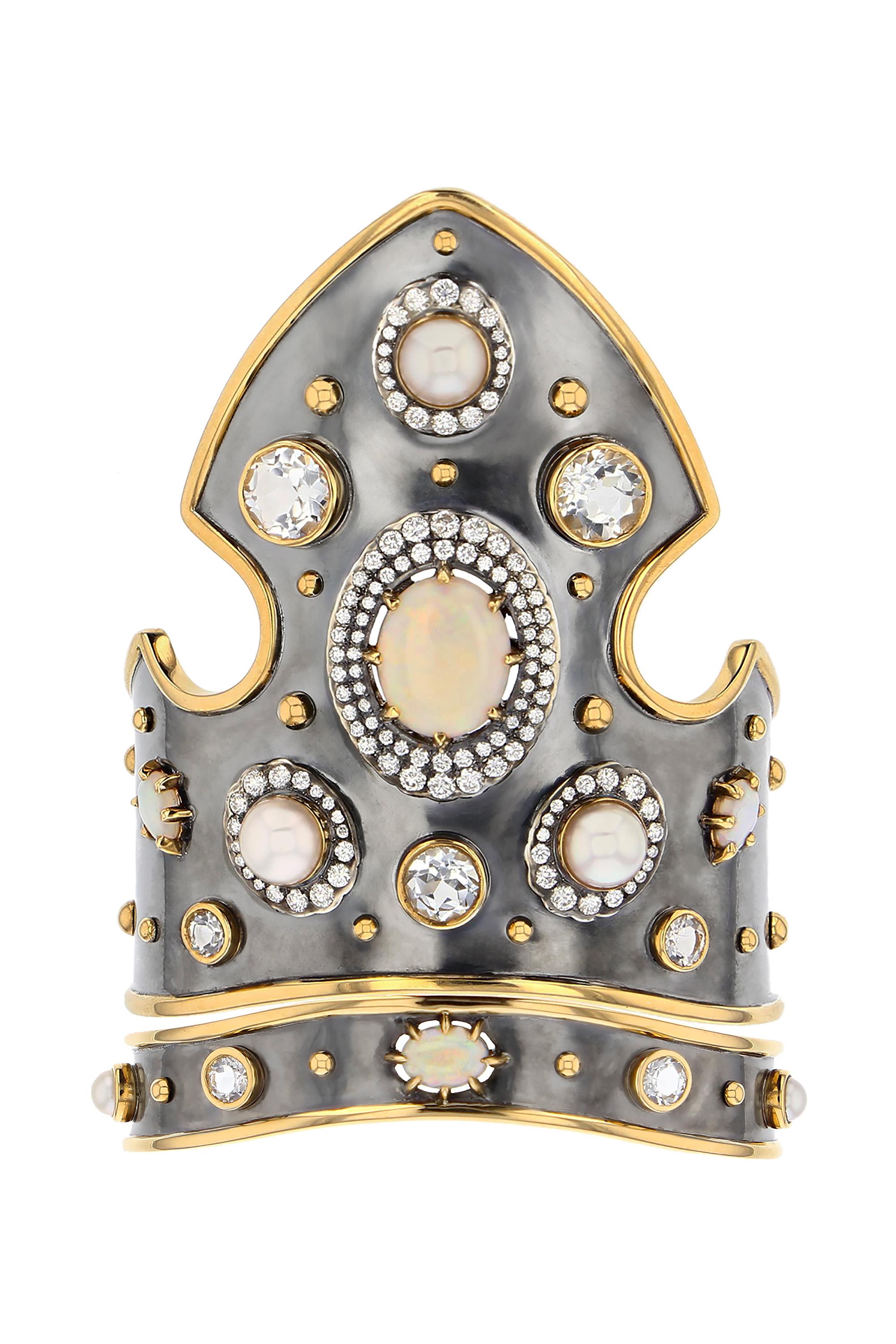 Manchette en or jaune et argent vieilli, sertie d'une opale, de perles d'akoya et de topazes blanches.

Détails :
Opale, topaze et perles d'Akoya
Diamants : 1,6 cts
Or jaune 18k : 28 g
Argent vieilli : 45 g
Fabriqué en France