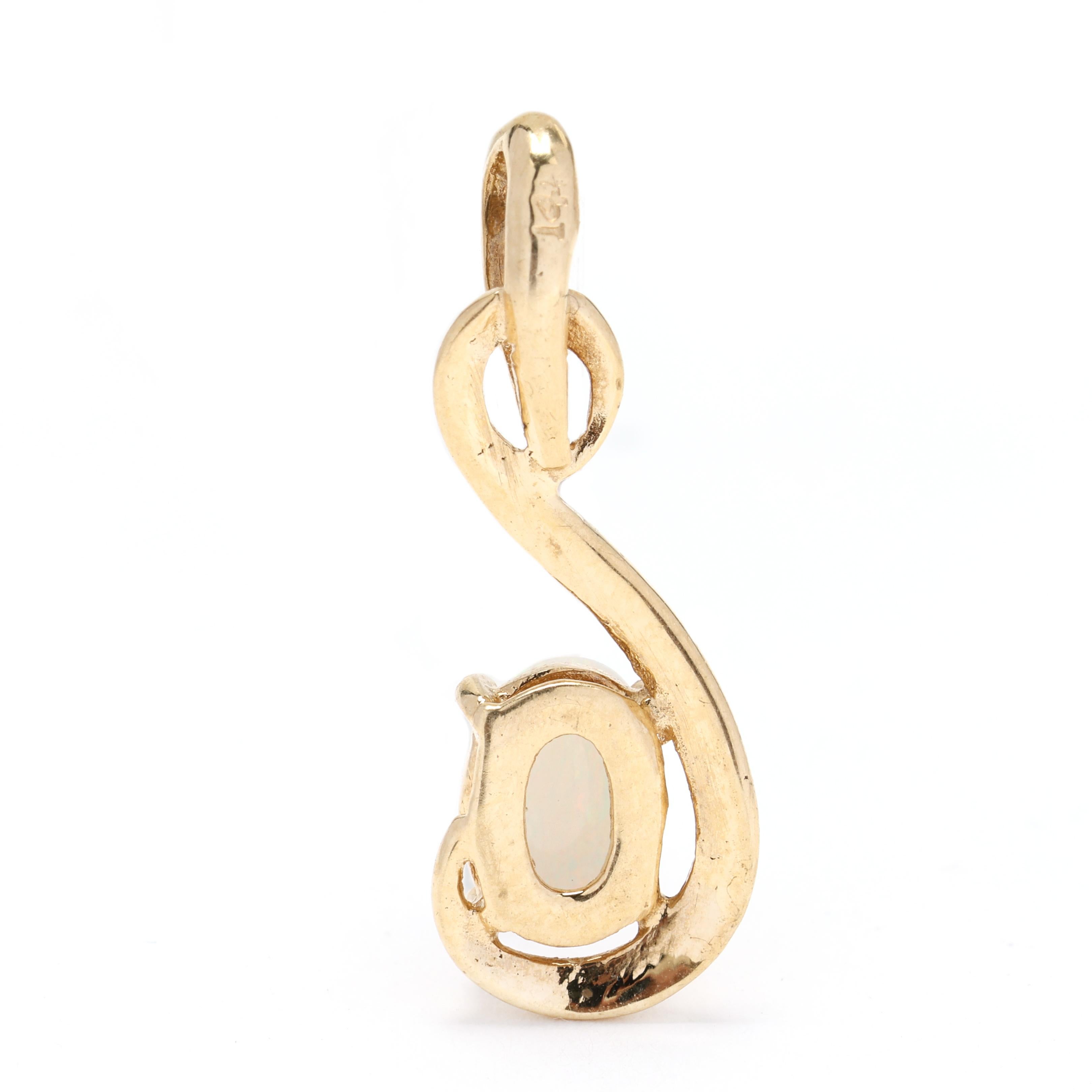 This stunning Opal Twisted Pendant is a perfect accessory to add some sparkle to your everyday look. The pendant is made from 14k yellow gold, giving it a warm and luxurious feel. The opal gemstone is known for its iridescent play-of-color, which