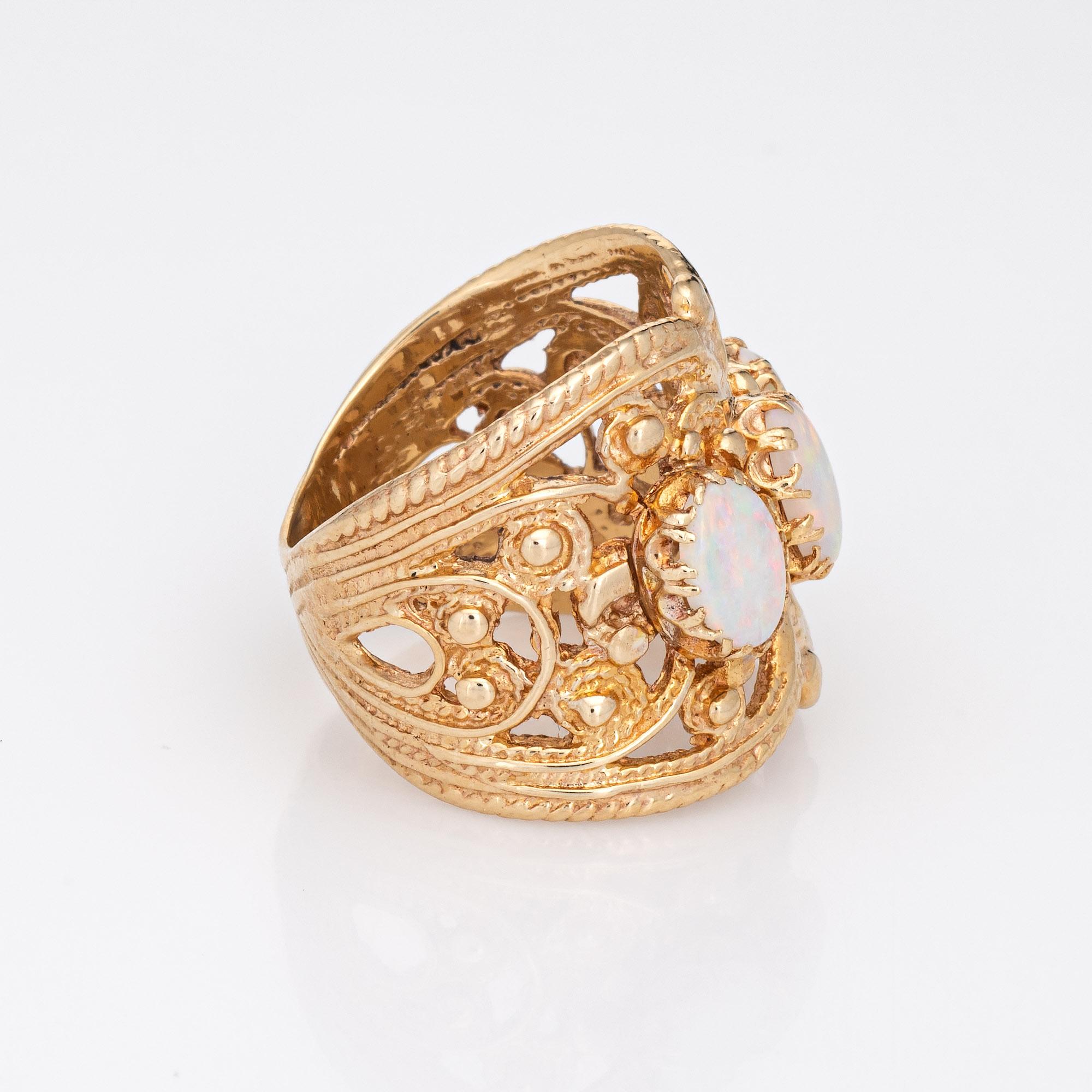 Stylish vintage opal wide band cigar ring crafted in 14 karat yellow gold. 

Three opal are estimated at 0.50 carats each and total an estimated 1.50 carats. The opals are in very good condition and free of cracks or chips.

The wide band ring (19mm