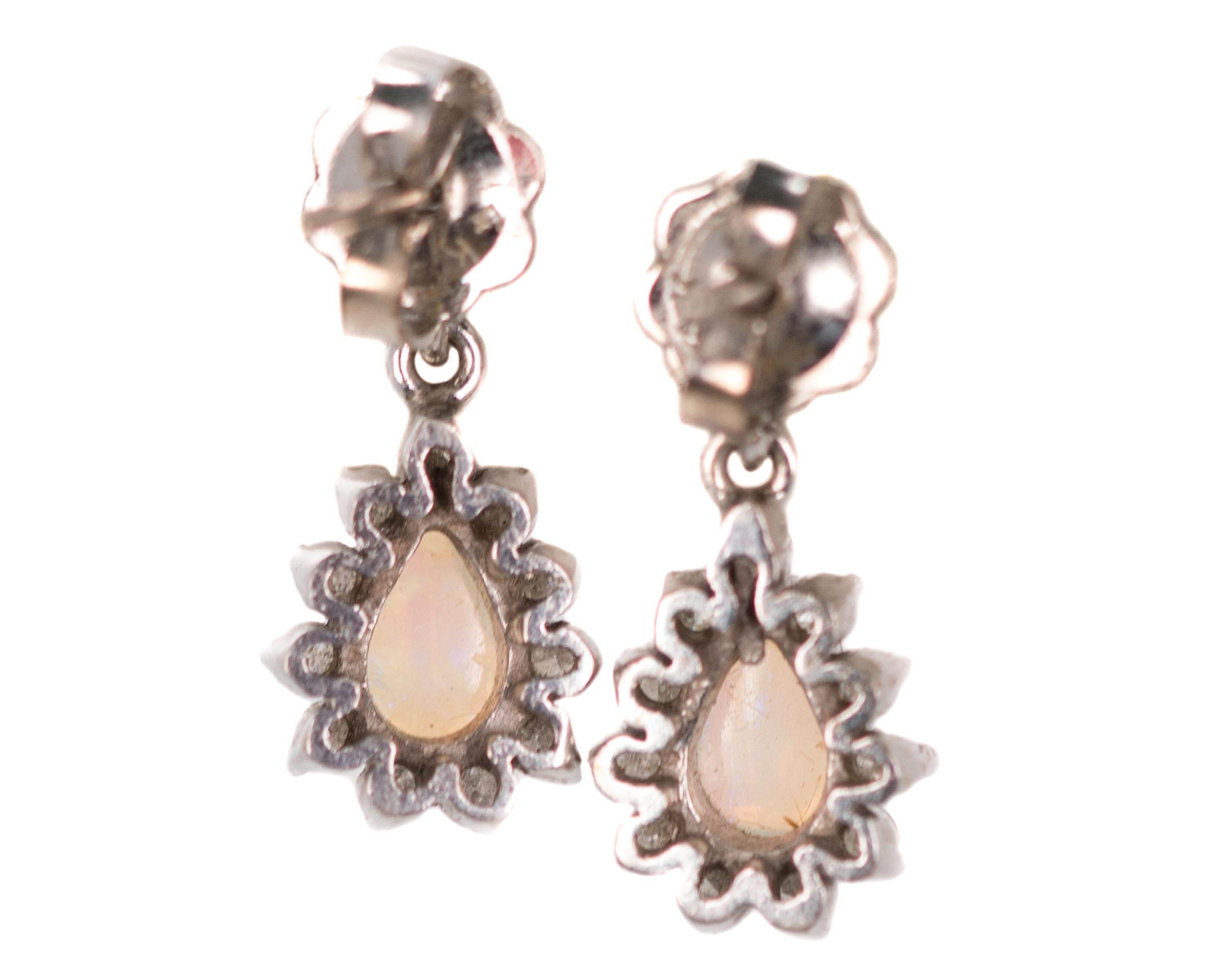 Opal and Diamond Drop Earrings - 14 Karat White Gold, Opals, Diamonds

Features:
Opal and Diamond Drops dangle from 14 Karat White Gold posts
14 Karat White Gold Settings, Posts and Backs
2 Pear Shaped Opal Center Stones
Opals have lively color play