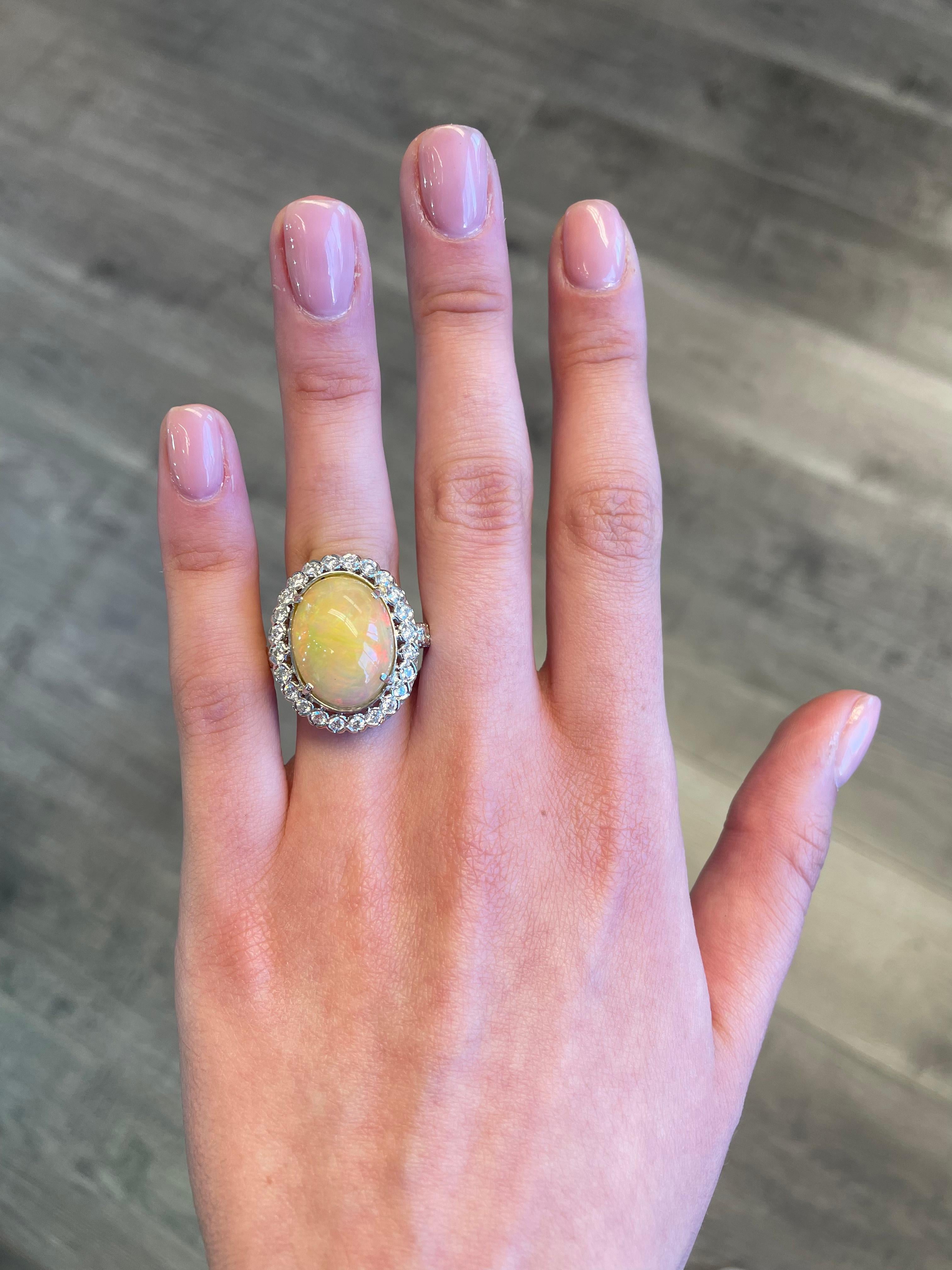 Opal with diamond halo ring.
Center white opal complimented by round brilliant diamonds, approximately G/H color and SI clarity. 18k white gold with filigree work, current ring size 8. 
Accommodated with an up to date appraisal by a GIA G.G. upon