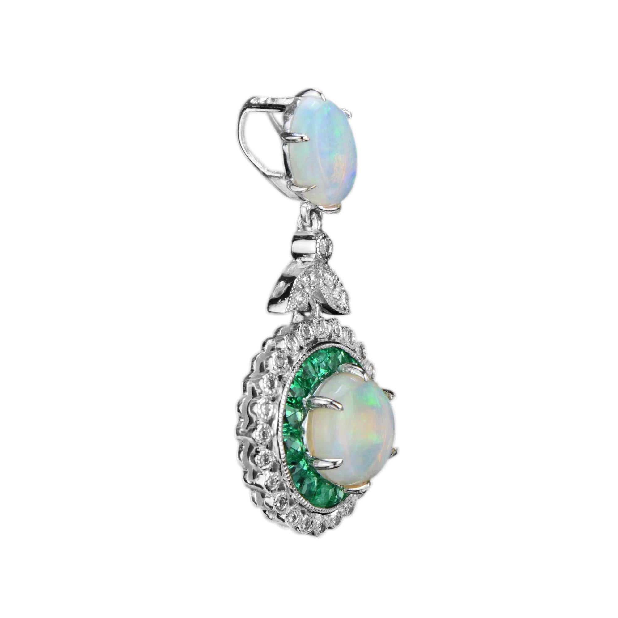 An Art Deco style opal with emerald and diamond halo pendant made with 18K white gold. The center opal is a 0.80 carat. It is surrounded by French cut emeralds that are cut by hand to fit seamlessly together. The emeralds are further enhanced by a