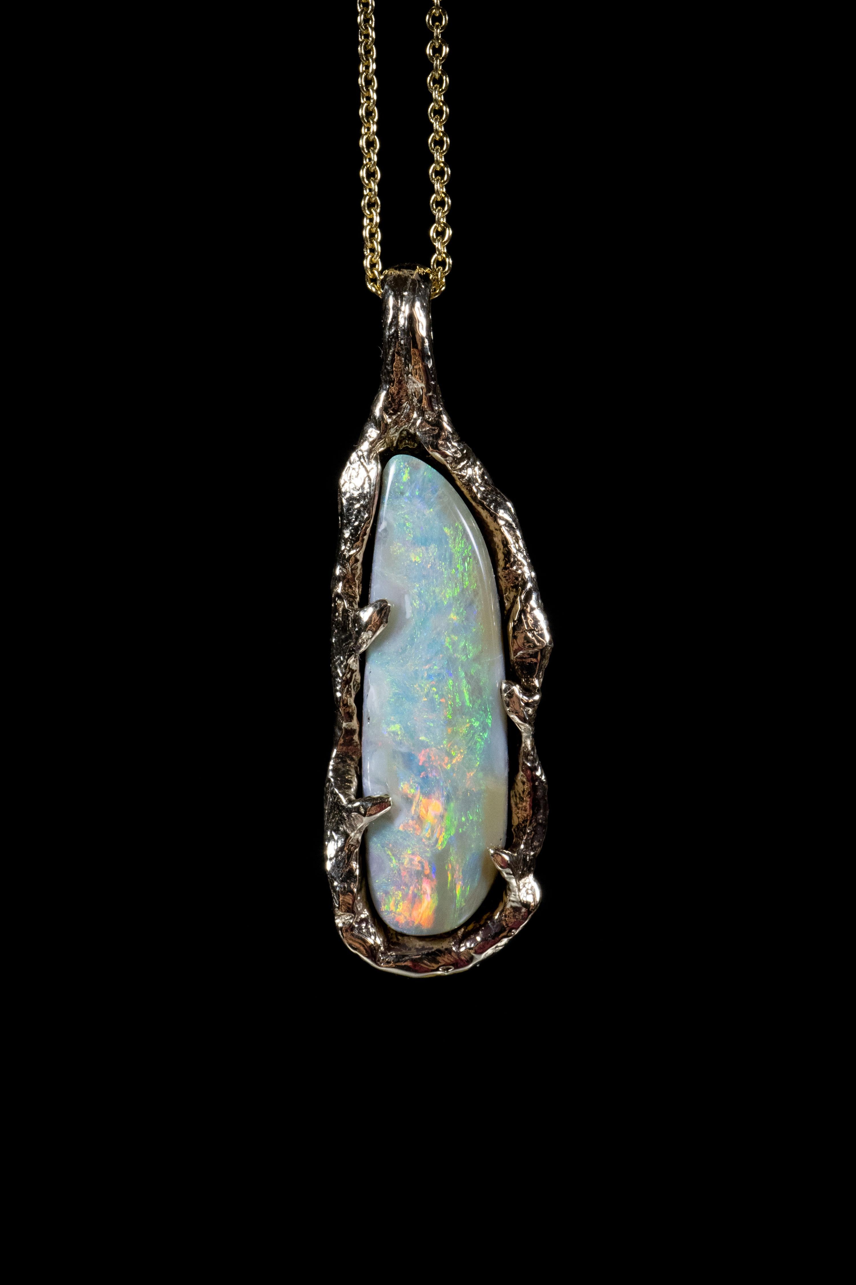 Opal World no. 3 is a one-of-a-kind pendant by Ken Fury that is hand-carved and cast in 14K solid yellow gold and features a stunning genuine Australian boulder opal. The gold entangles the stone like a vine, holding onto it, protecting its light.