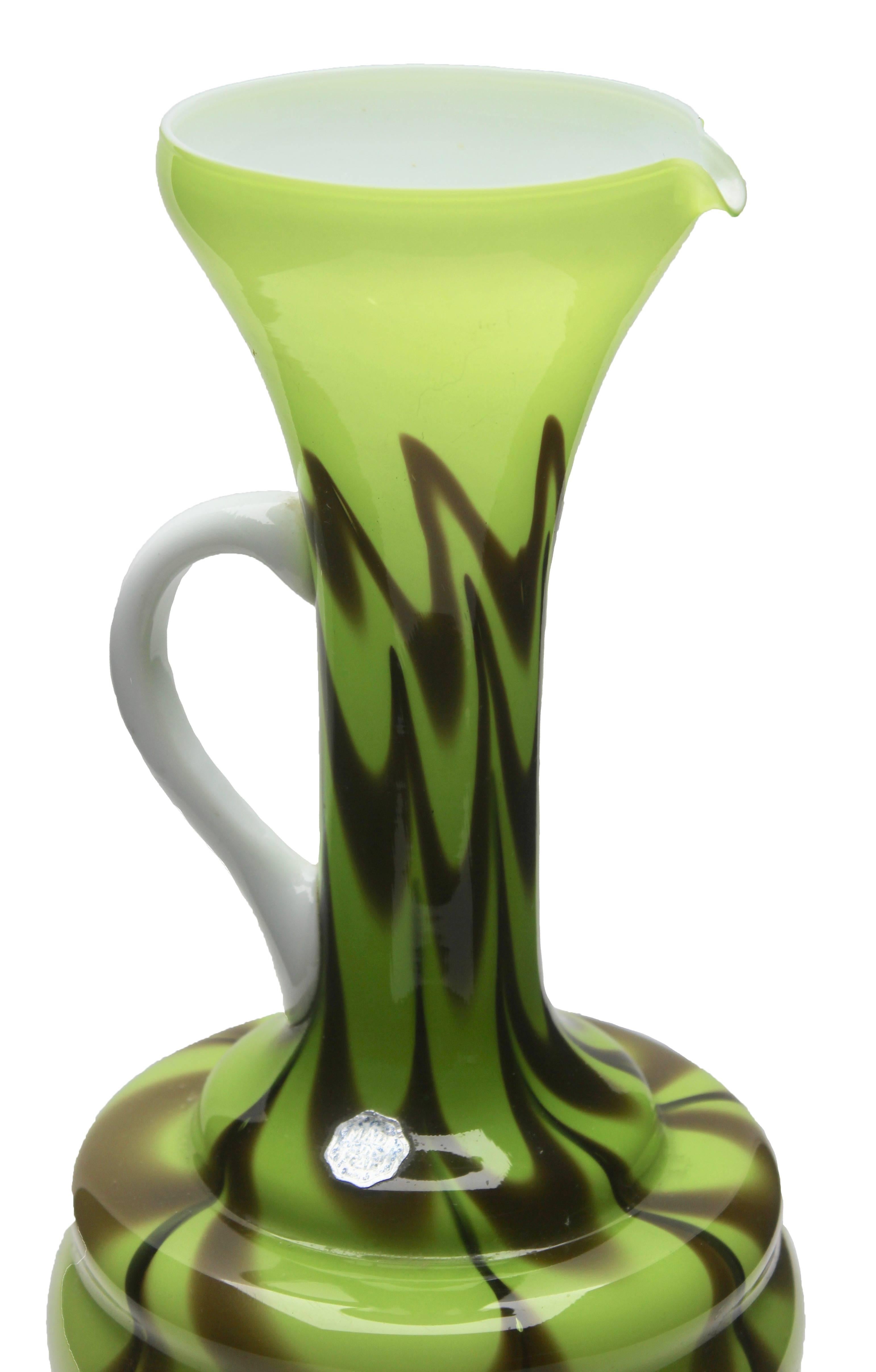Opaline di Florence (Empoli) opalescent green and brown Italian art glass pitcher with early factory label dating it to the late 1950s or early 1960s. 

Beautiful hand-blown opal (green, brown) and hand-applied white handle. 
Measures: 12.2 inches