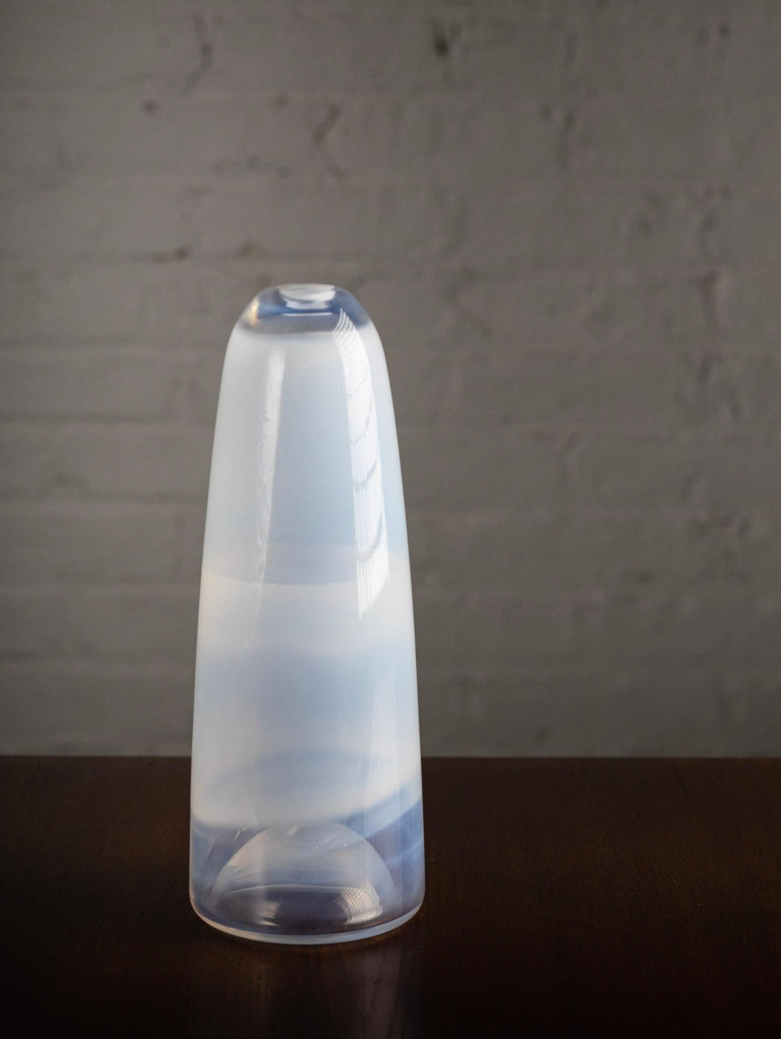 A hand blown opalescent glass vase. Transparent colors ranging from white to the palest shades blue. Bullet form silhouette. Mouth opening measures .75